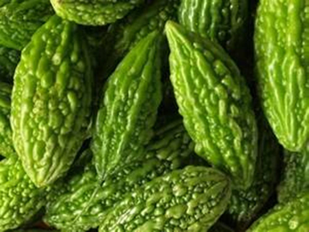 Greenery 桌布 壁紙 — 鮮綠色苦瓜的特寫，表面凹凸不平，堆疊在一起。