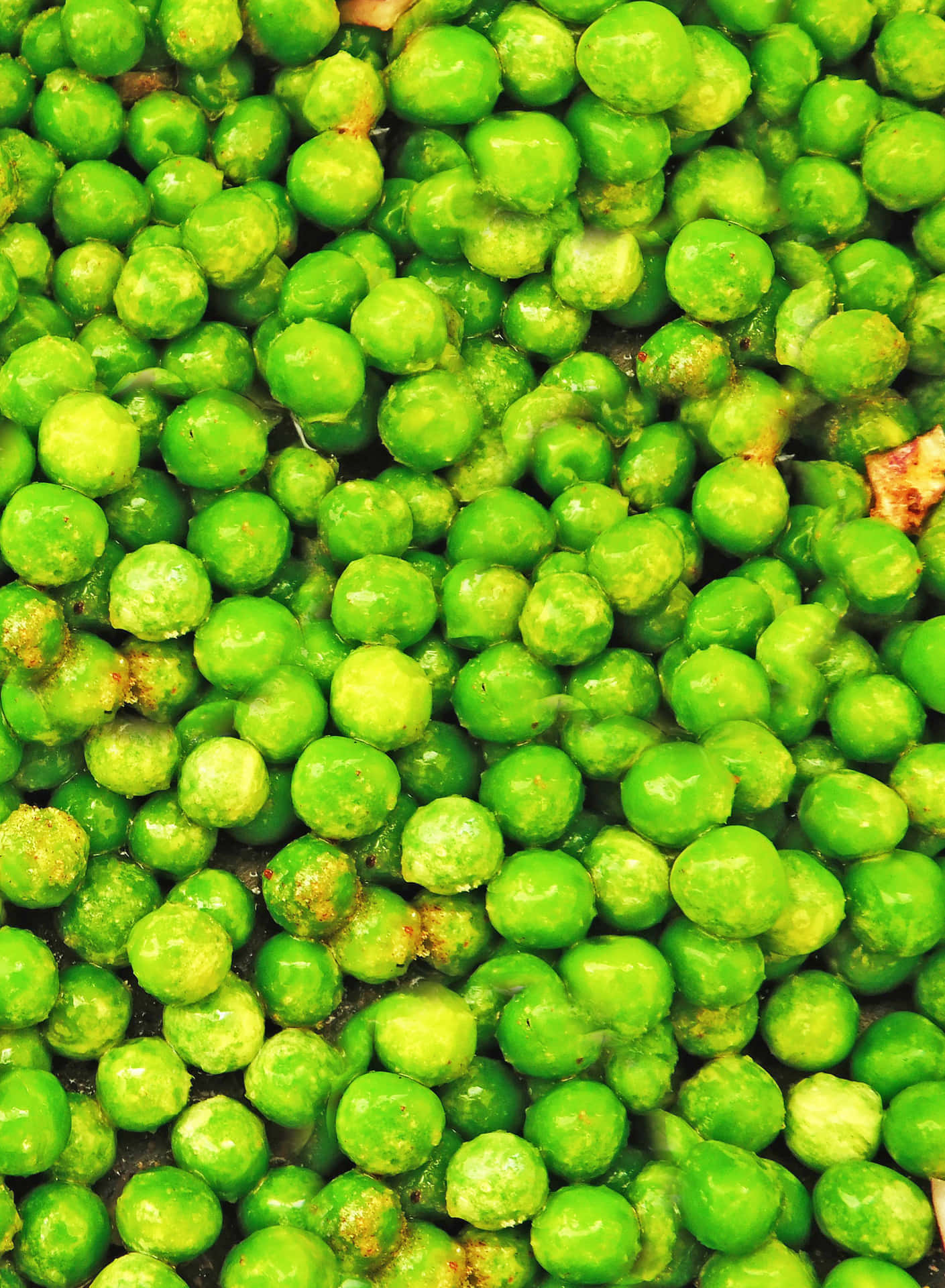 Peas 壁紙 — 鮮綠色豌豆的特寫，閃爍著水分，並帶有泥土般的棕色斑點。