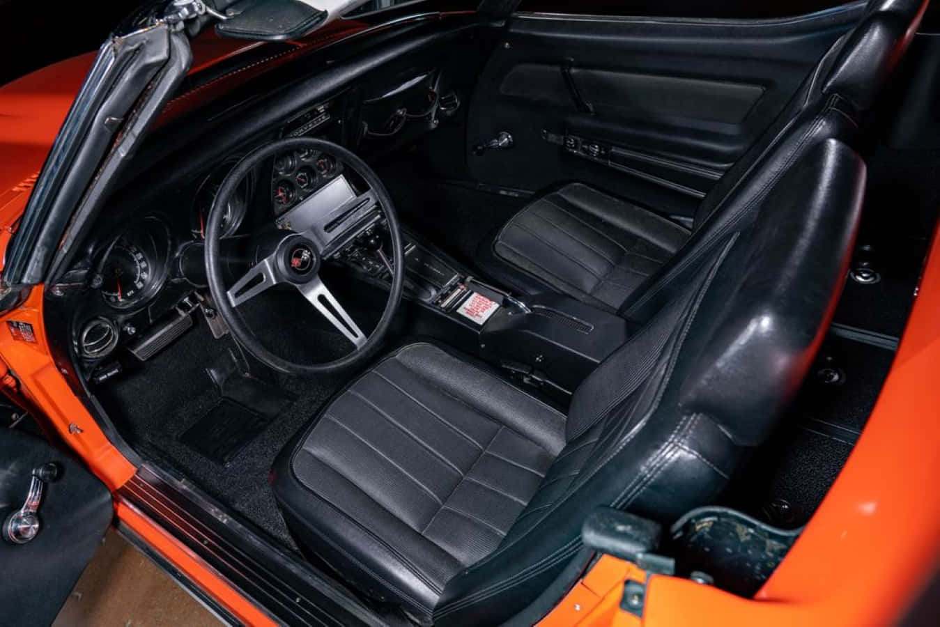 Chevrolet Corvette Zl1 桌布 壁紙 — 鮮豔橙色經典跑車內裝，搭配黑色皮革座椅和復古儀表板細節。