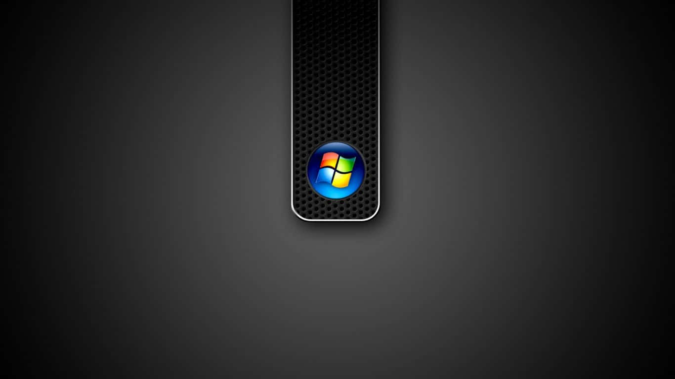 Windows 7 桌布 壁紙 — 鮮豔的Windows標誌在光滑的黑色穿孔面板上發光，背景為深灰色漸變。