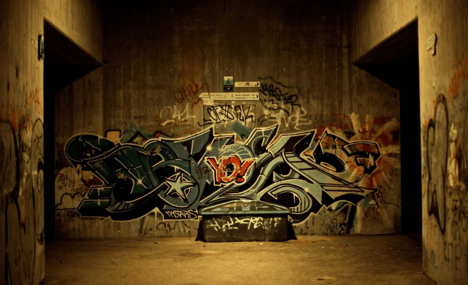 hiphop 桌布 壁紙 — 鮮豔的塗鴉藝術以大膽的色彩主導了一條光線昏暗的混凝土小巷，牆壁破舊，門口黑暗。