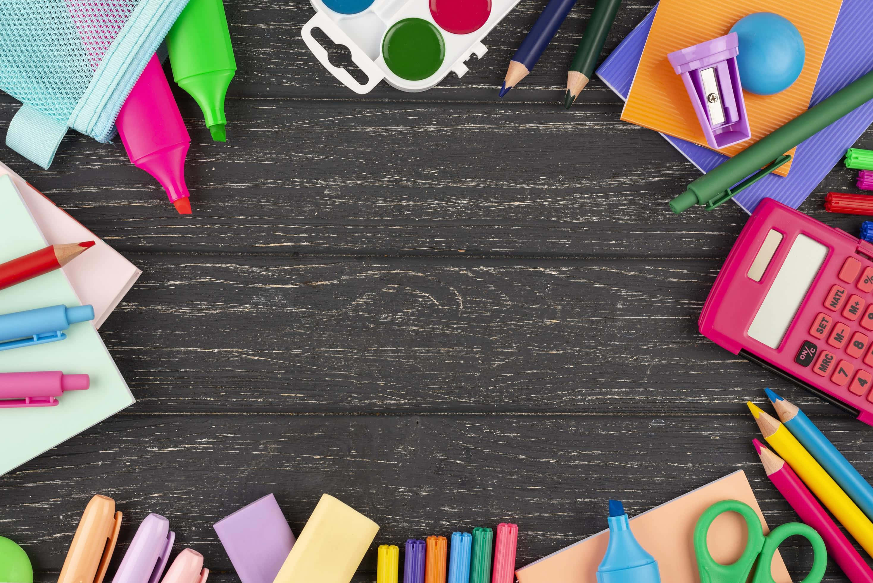 Back To School 桌布 壁紙 — 鮮豔的學校用品以明亮的色彩框住深色木桌的俯視圖。