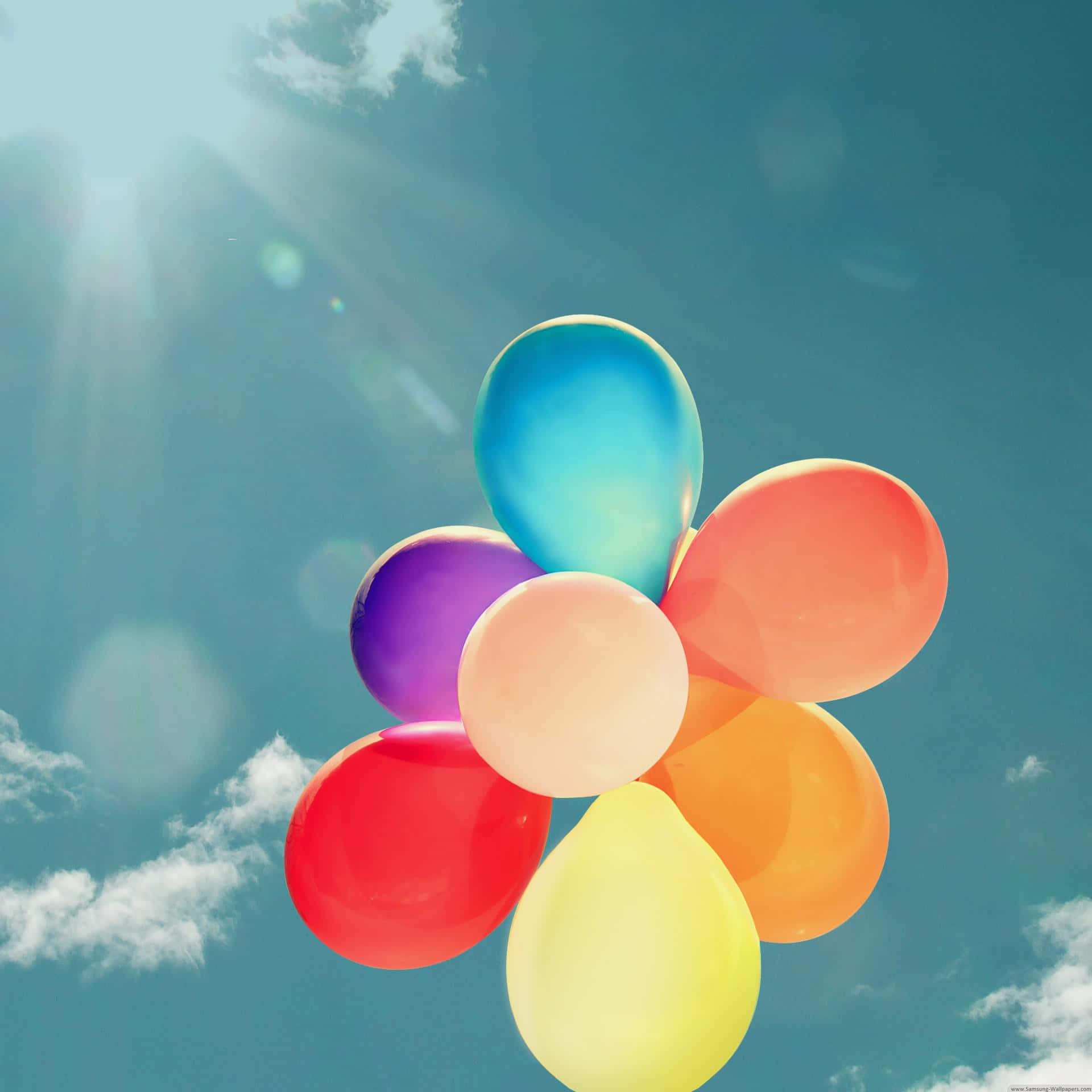 Balloon 桌布 壁紙 — 鮮豔的彩虹氣球在陽光明媚、雲朵柔軟的藍天中飄浮。