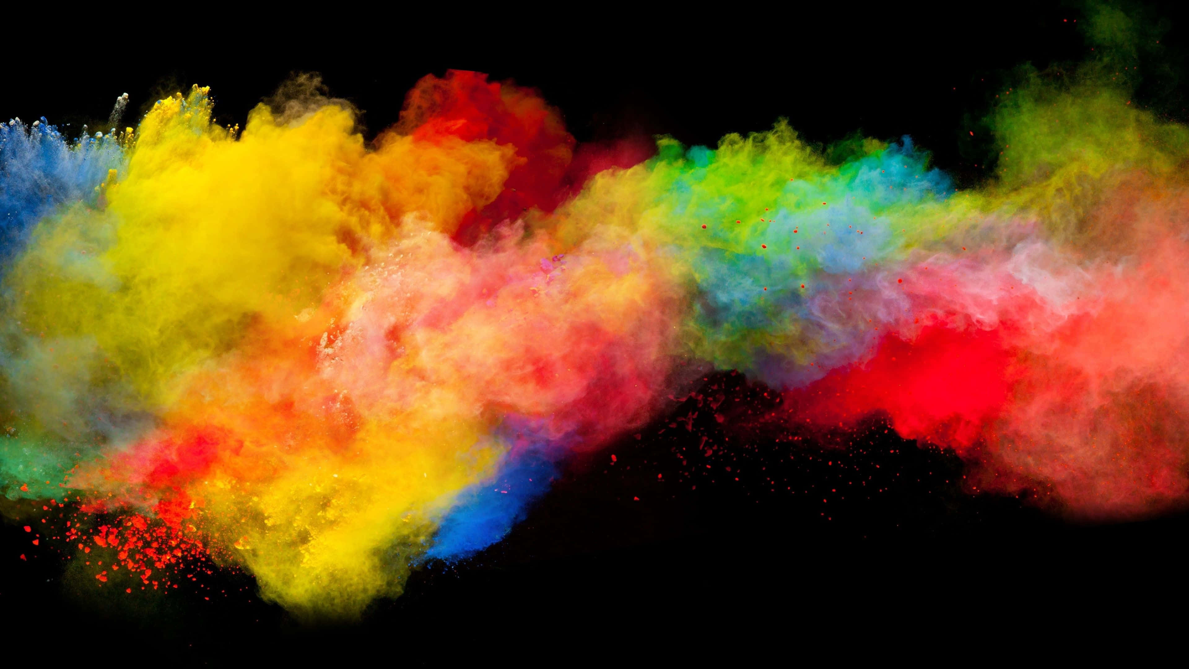 Color Smoke 桌布 壁紙 — 鮮豔的彩虹粉末在半空中爆炸，在純黑背景上形成動態的色彩爆發。