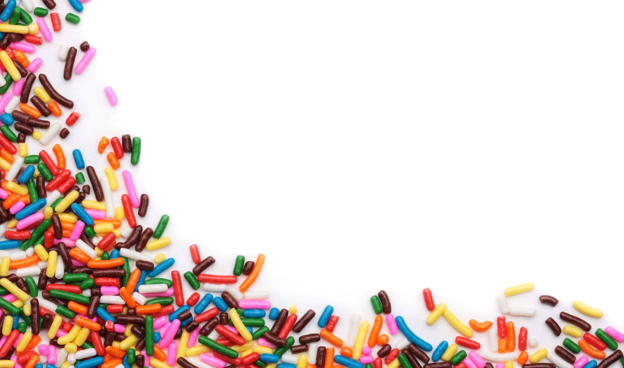 Sprinkles 桌布 壁紙 — 鮮豔的彩虹糖屑以對角線方式灑落在純白背景上，營造出節日甜蜜角落。