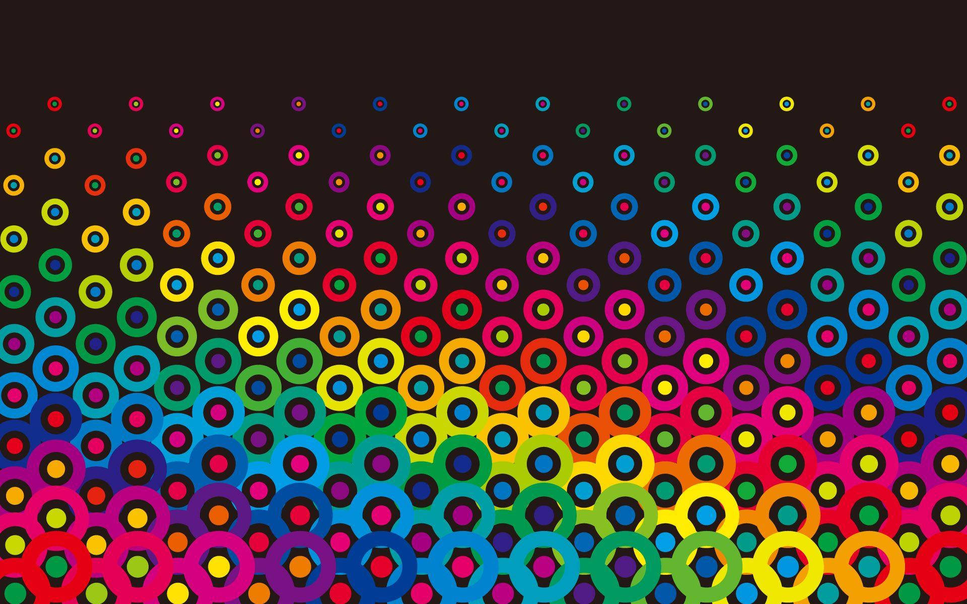 Cool Colorful 桌布 壁紙 — 鮮豔的彩虹色同心圓在深色背景上以對角線方式層疊，形成大膽的幾何圖案。