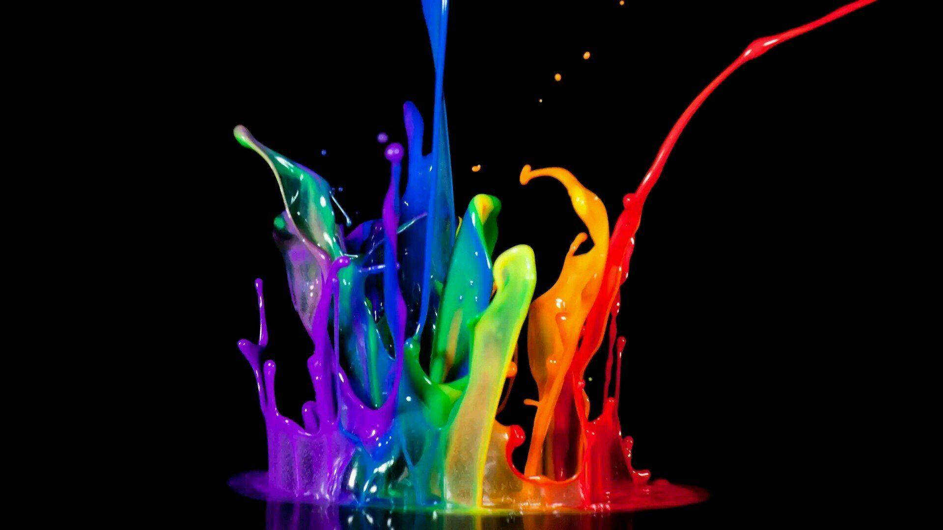 LGBT 桌布 壁紙 — 鮮豔的彩虹顏料噴濺在黑色背景上爆炸，形成動態的色彩爆發。