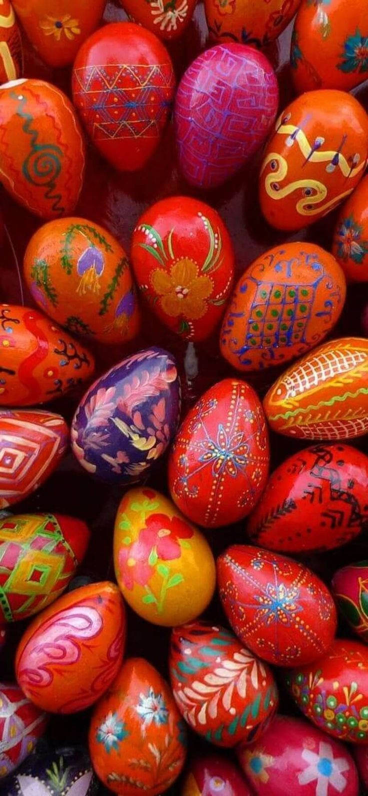 Easter Phone 桌布 壁紙 — 鮮豔的手繪復活節彩蛋，紅色、橙色和紫色，帶有花卉和幾何圖案，緊密聚集在一起。