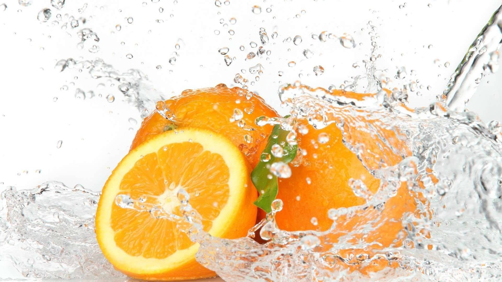 Orange Fruit 桌布 壁紙 — 鮮豔的橙片和整顆橙子在純白背景上爆開，水珠四濺。
