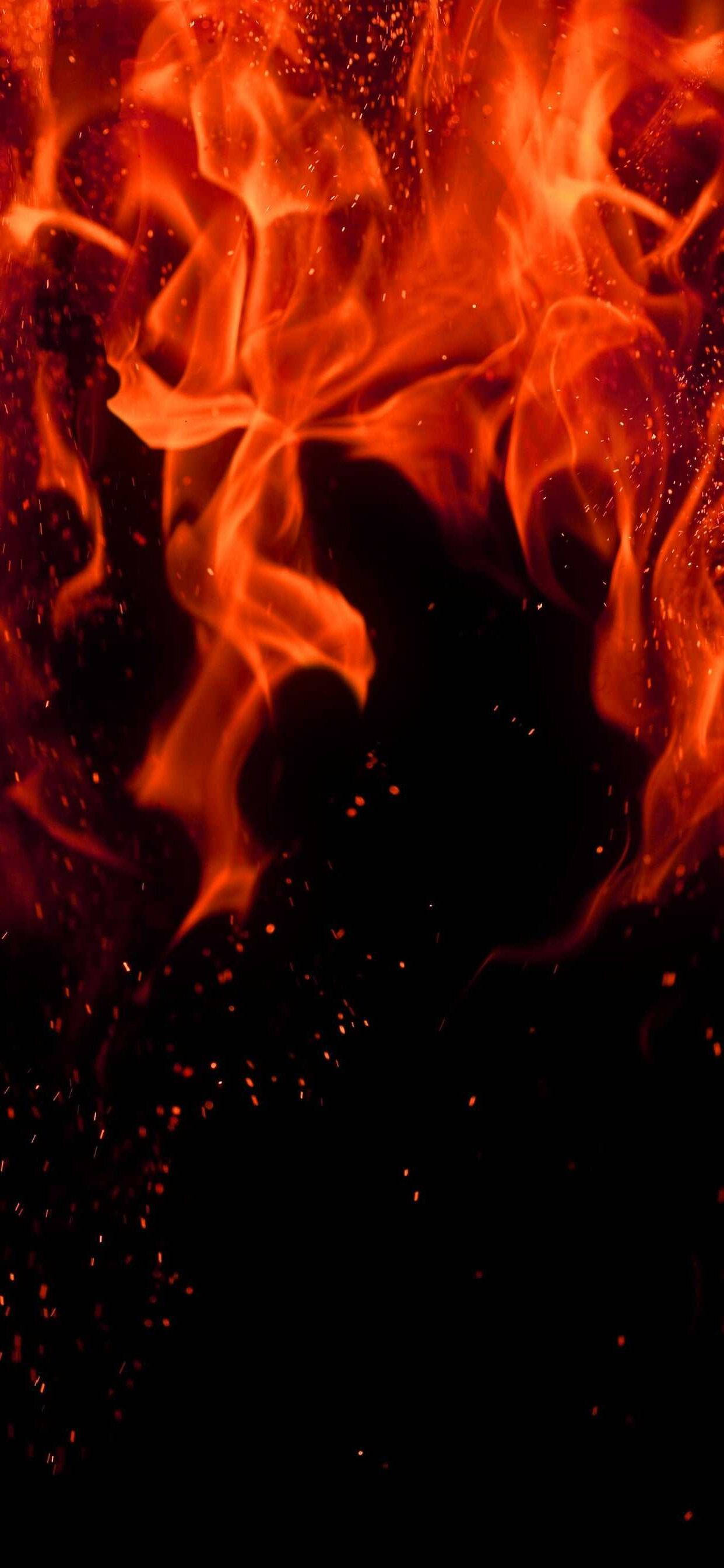 Red Fire 桌布 壁紙 — 鮮豔的橙色和紅色火焰在漆黑的背景上動態舞動，周圍漂浮著發光的餘燼。