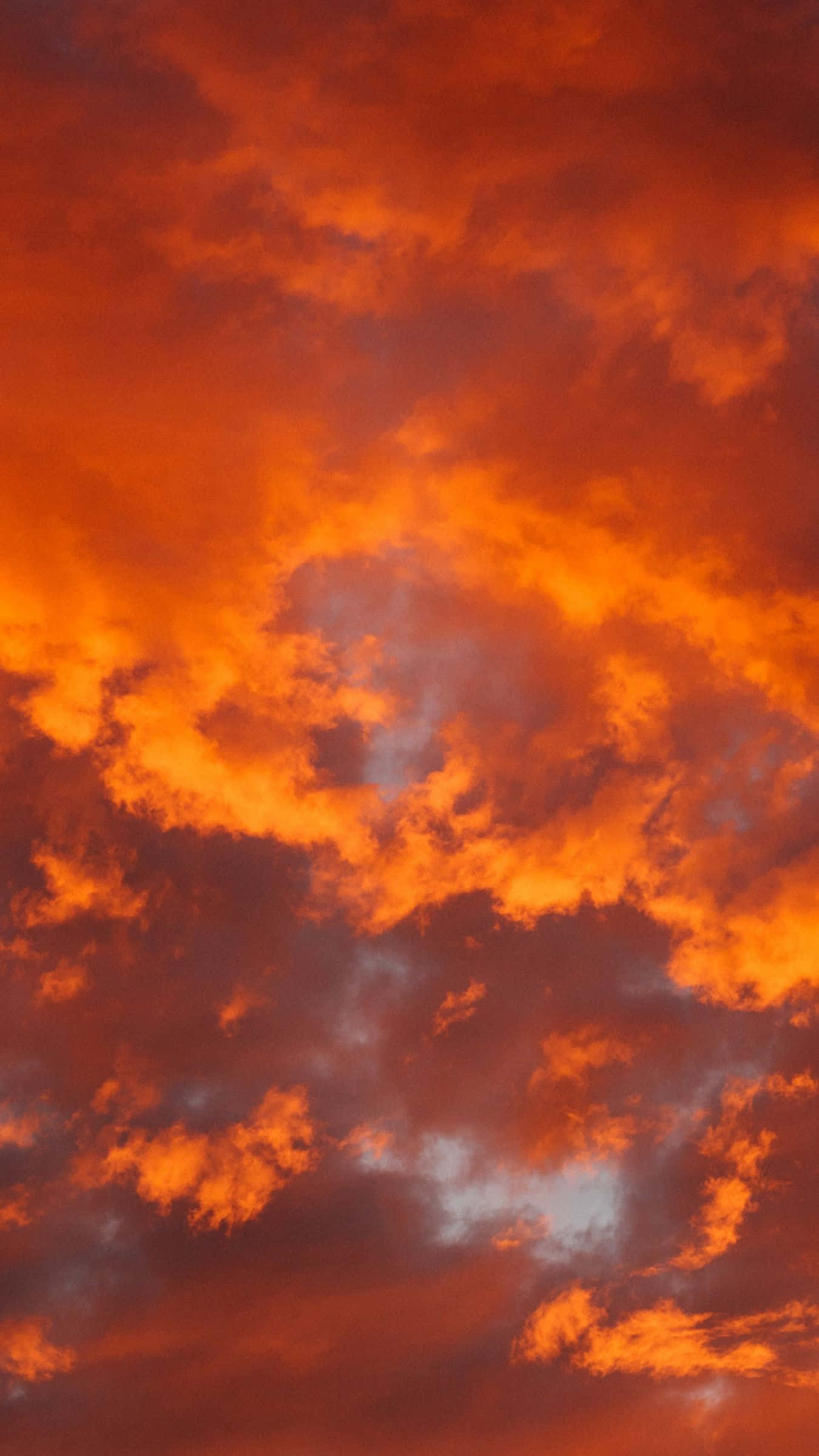 Clouds Aesthetic Tumblr 桌布 壁紙 — 鮮豔的橙色和紅色雲彩在帶有灰色調的熾熱日落天空中戲劇性地旋轉。
