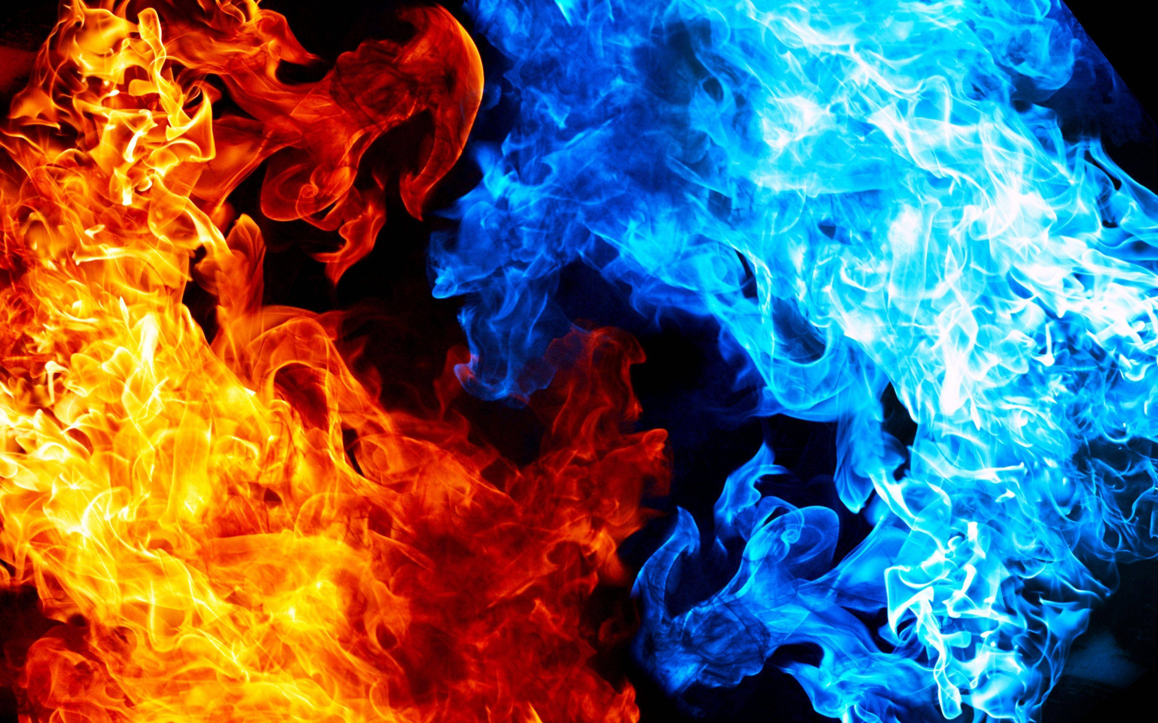Fire And Ice 桌布 壁紙 — 鮮豔的橙色和電光藍色火焰在黑色背景上動態碰撞，形成熾熱的抽象構圖。