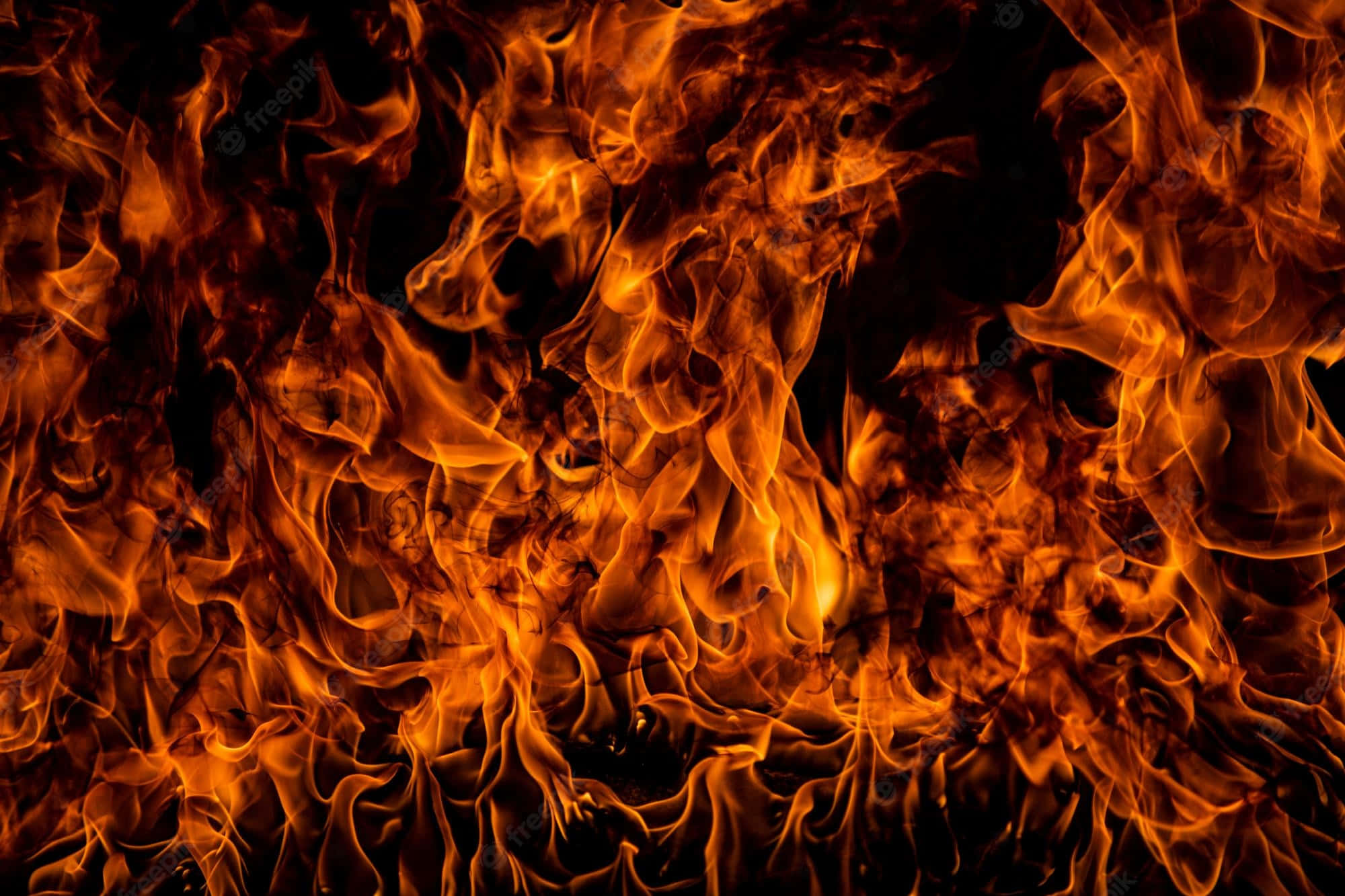 Flame 桌布 壁紙 — 鮮豔的橙色和黃色火焰在漆黑的背景上動態舞動，營造出強烈的熱量和運動感。