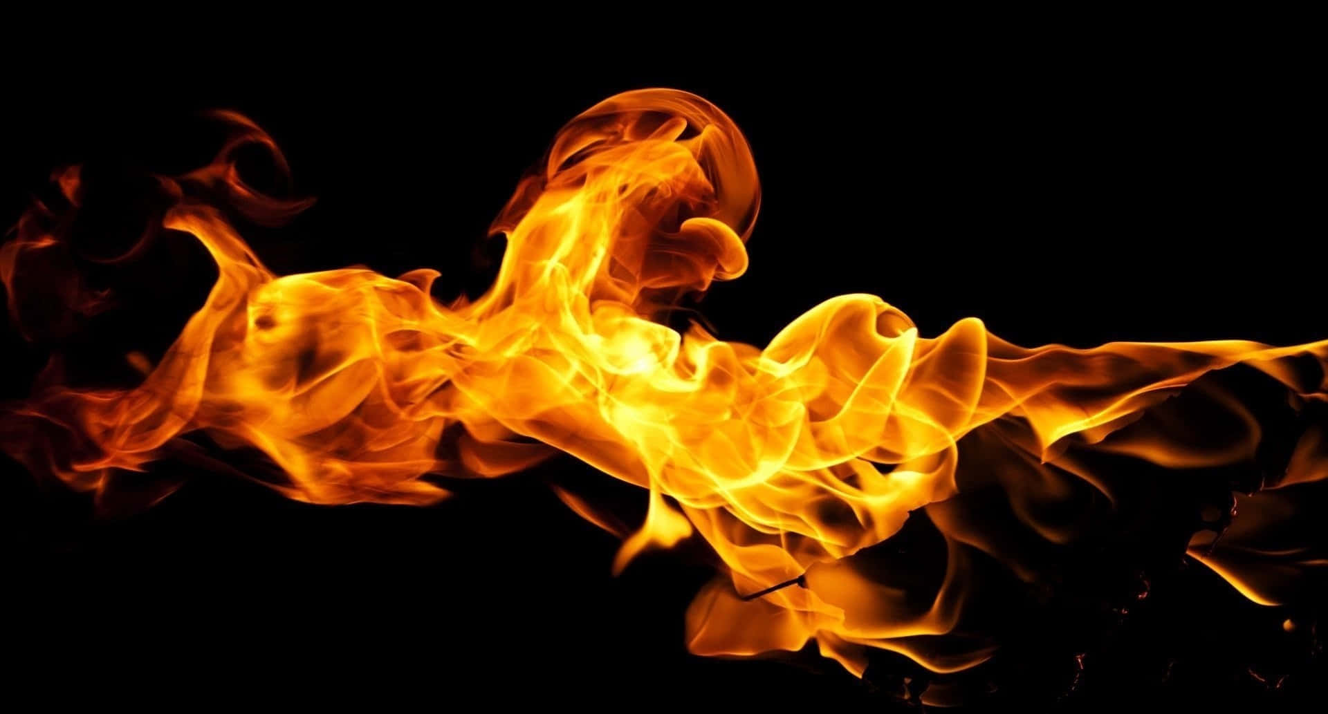 Flames 桌布 壁紙 — 鮮豔的橙色和黃色火焰在純黑色背景上動態扭轉，營造出強烈的視覺對比。