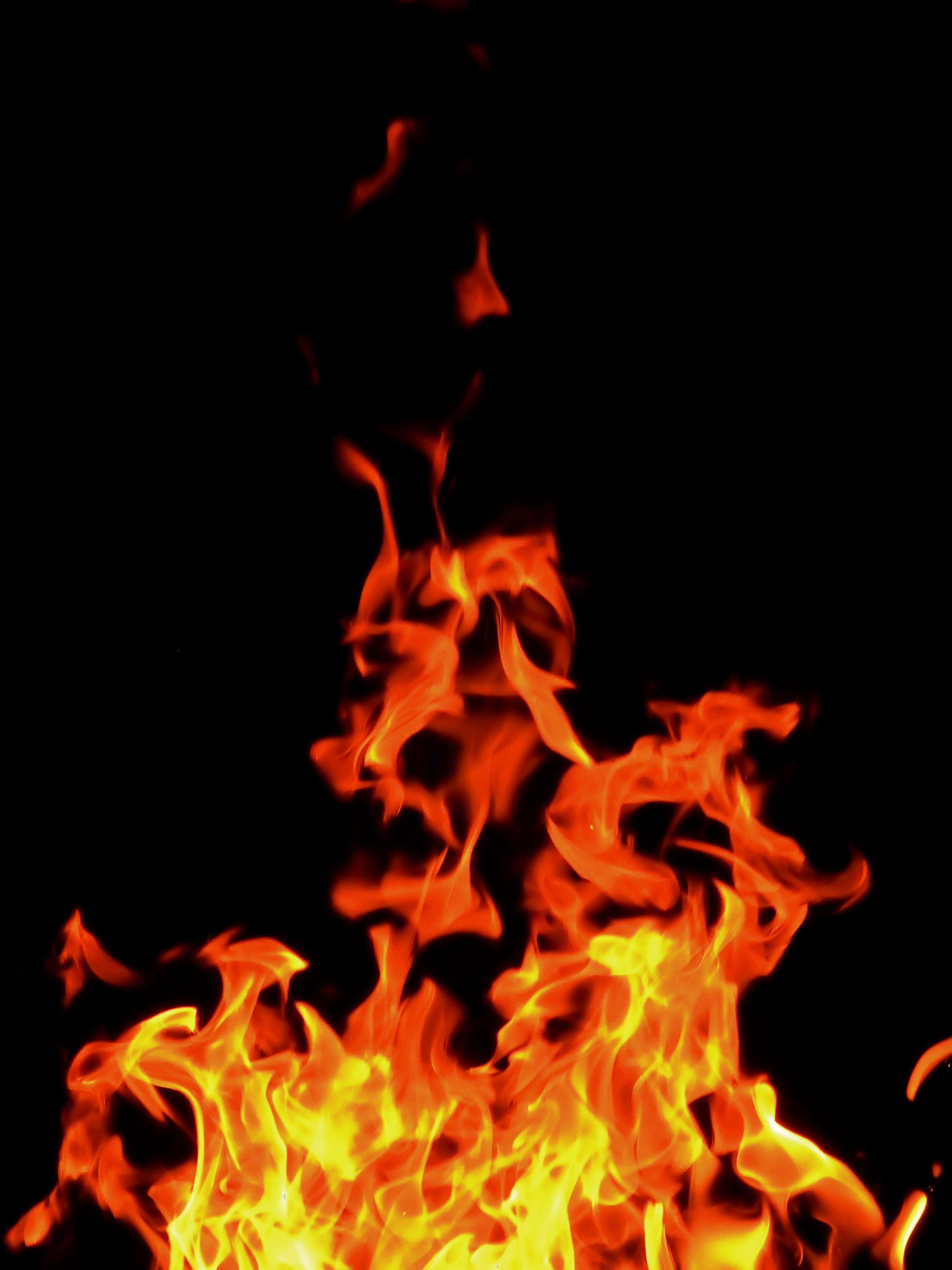 Burn 桌布 壁紙 — 鮮豔的橙色和黃色火焰在純黑色背景上動態舞動，營造出強烈的視覺對比。