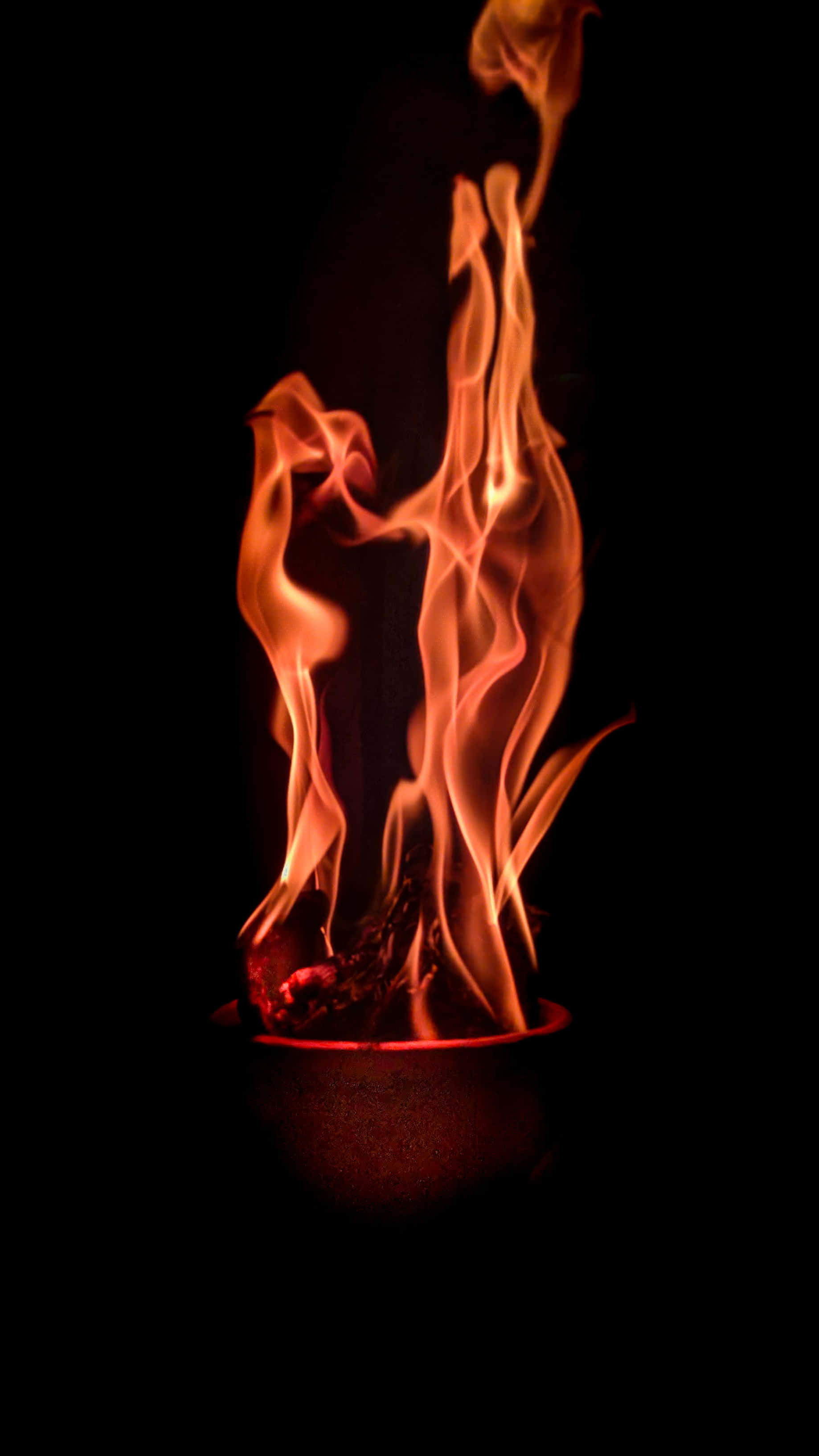 Red Fire 桌布 壁紙 — 鮮豔的橙色火焰從一個深色碗中向上舞動，背景為純黑色。