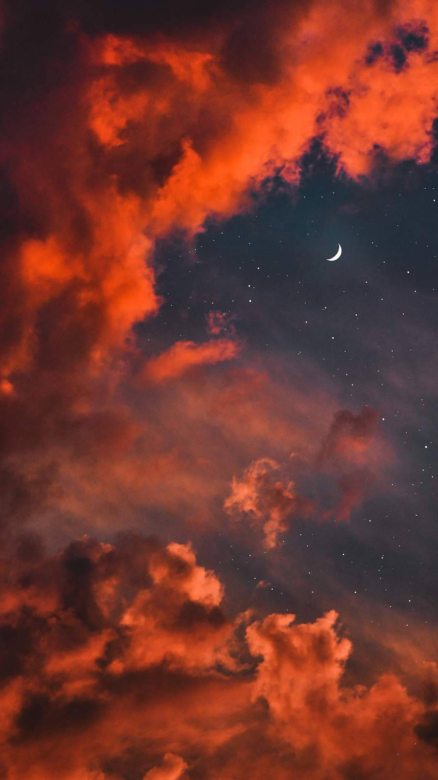 月光 桌布 壁紙 — 鮮豔的橙色雲朵在繁星點點的夜空下翻騰，一彎新月在上方柔和發光。