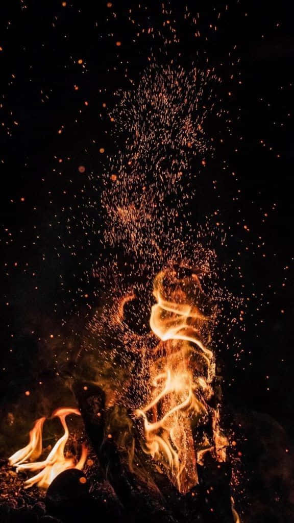 火焰動畫 桌布 壁紙 — 鮮豔的火焰和發光的餘燼在漆黑的夜空中向上爆發，形成動態的火焰展示。