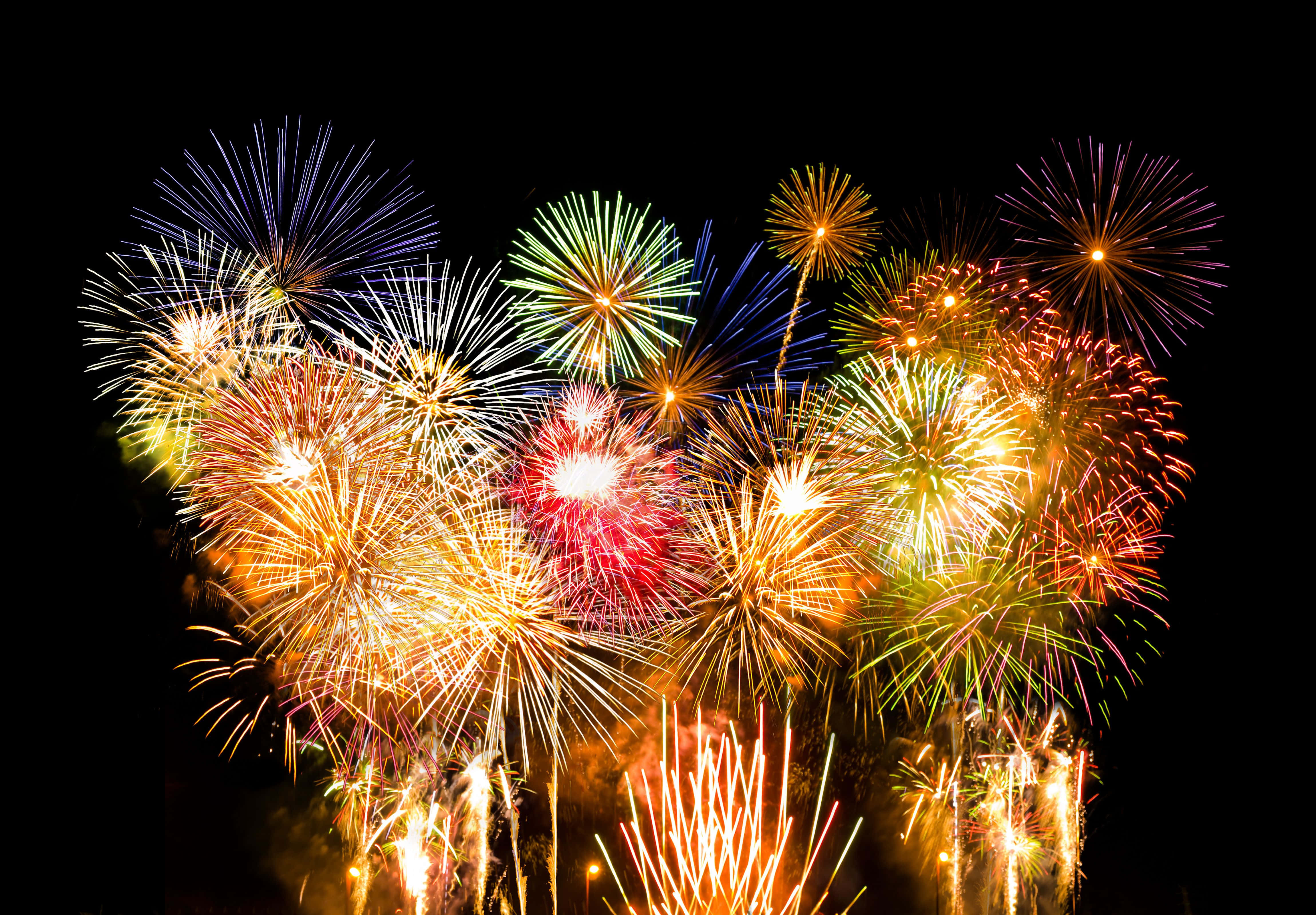 firework 桌布 壁紙 — 鮮豔的煙火在漆黑的夜空中綻放出紅、金、綠、藍色的耀眼光芒。