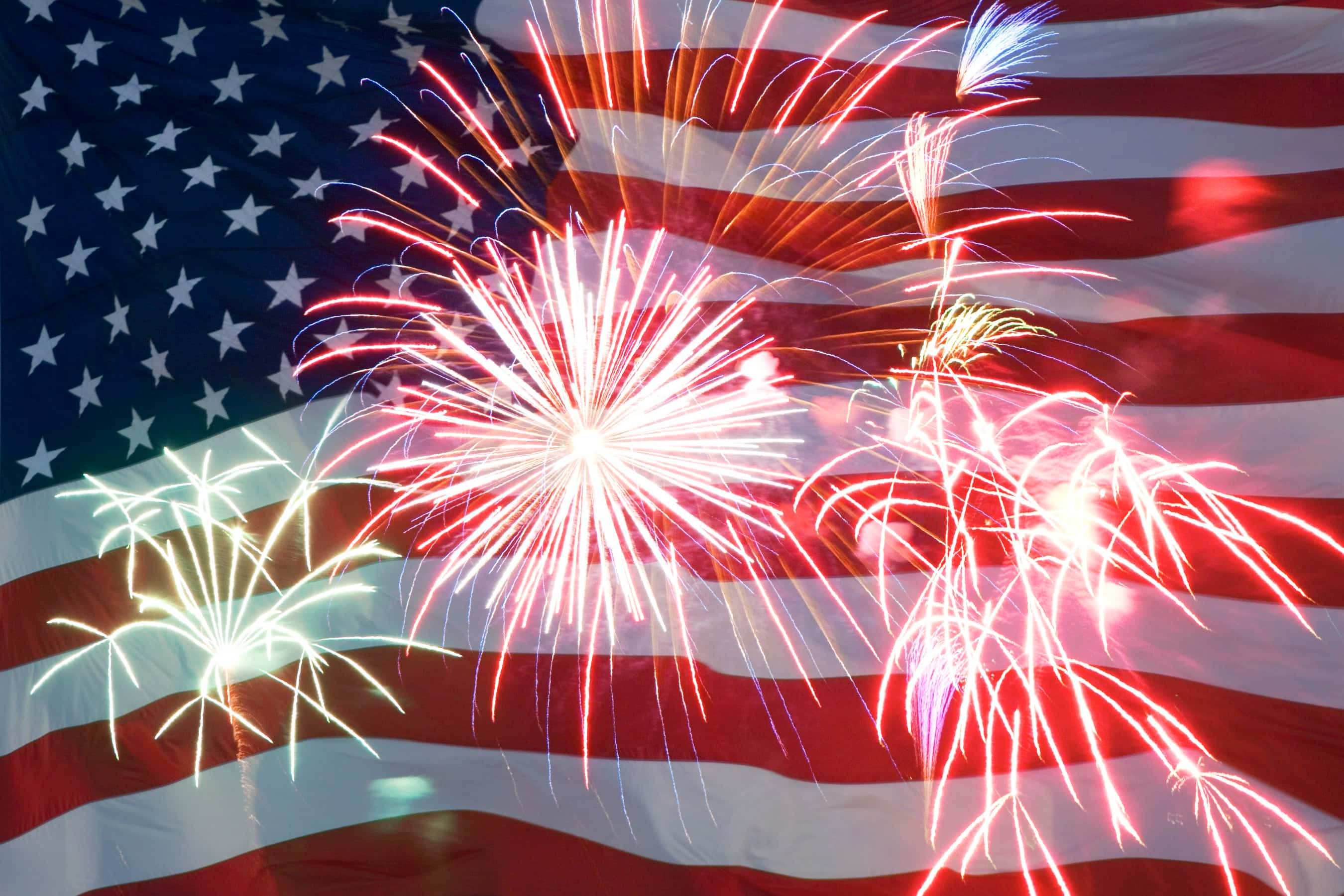 Cute 4th Of July 桌布 壁紙 — 鮮豔的煙火在飄揚的美國國旗背景下爆炸，營造出耀眼的愛國展示。