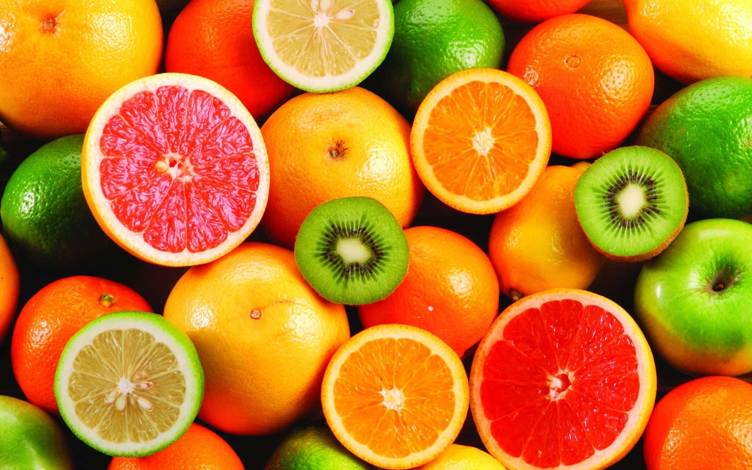 Fruit 桌布 壁紙 — 鮮豔的特寫鏡頭，展示各種柑橘類水果和奇異果切片，露出多汁的內部。