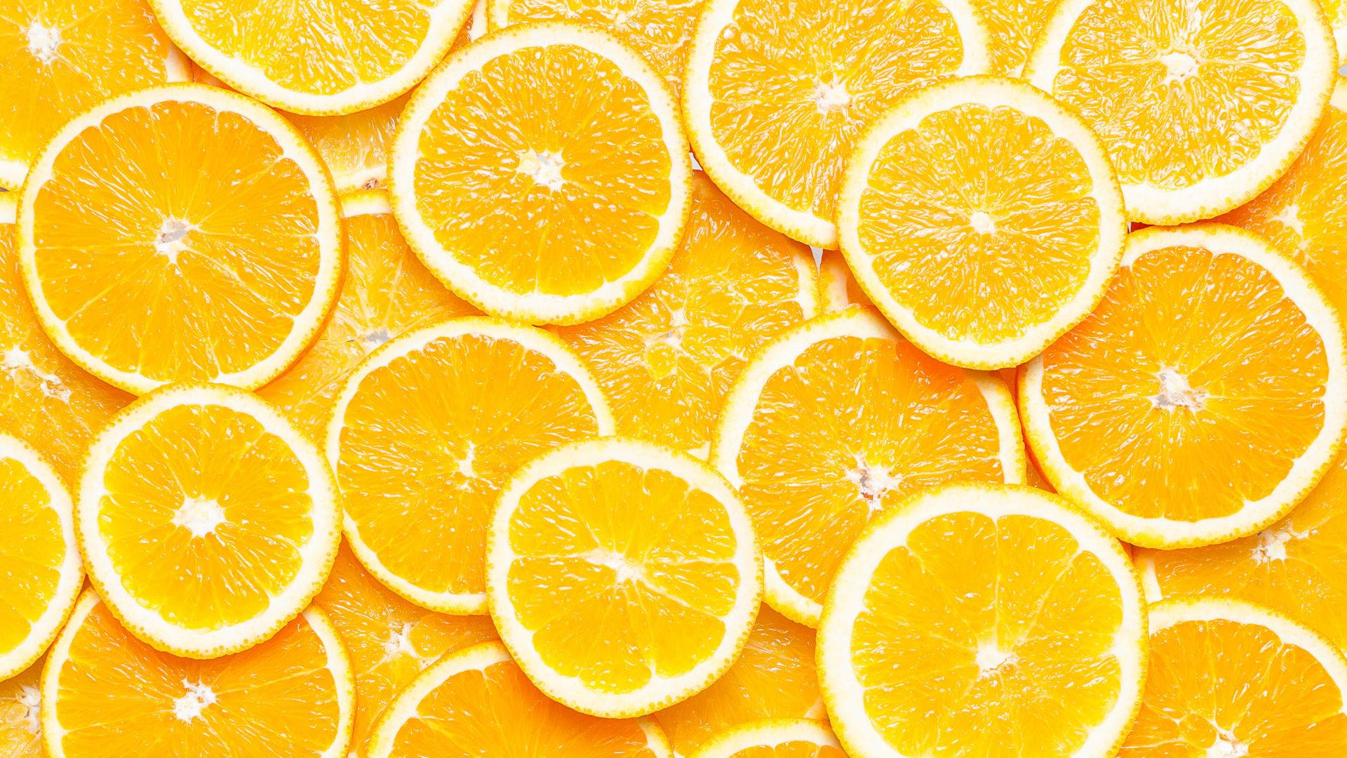 Orange Fruit 桌布 壁紙 — 鮮豔的特寫鏡頭，重疊的橙片展現出多汁的果肉和明亮的柑橘果肉。