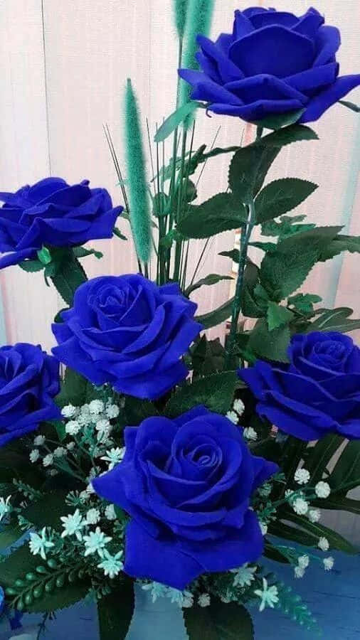 Rose Flower 桌布 壁紙 — 鮮豔的皇家藍玫瑰配以綠色葉片和細小白花，組成豐盛的花束。