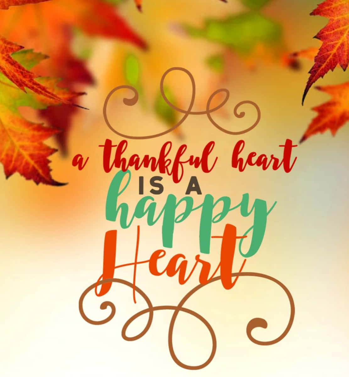 Thankful 桌布 壁紙 — 鮮豔的秋葉框住了優雅的手寫文字，上面寫著「a thankful heart is a happy heart」，背景是溫暖的漸變色。