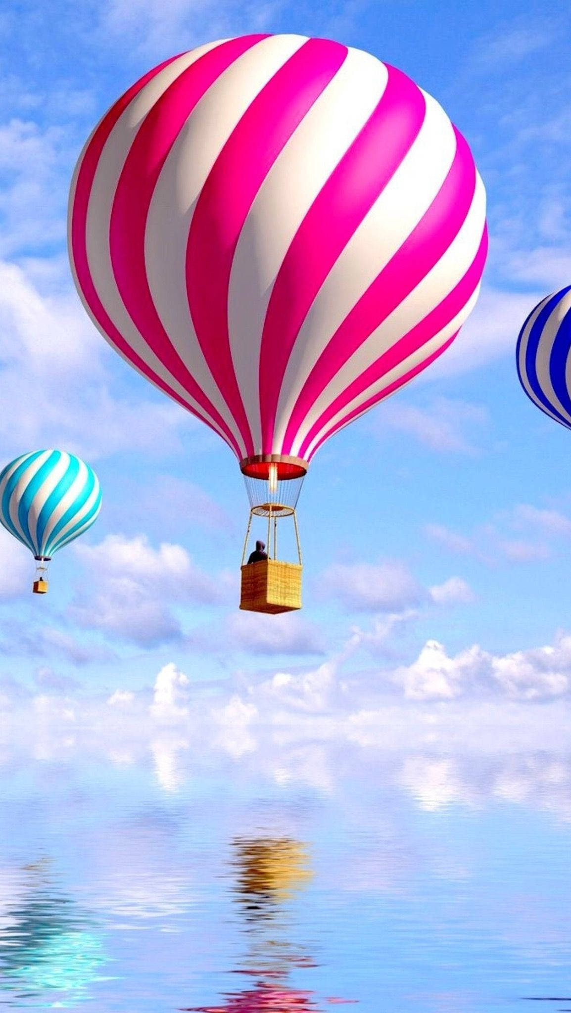 Hot Air Balloon 桌布 壁紙 — 鮮豔的粉紅和白色條紋熱氣球漂浮在平靜的藍色水面上，天空明亮，有蓬鬆的雲朵。