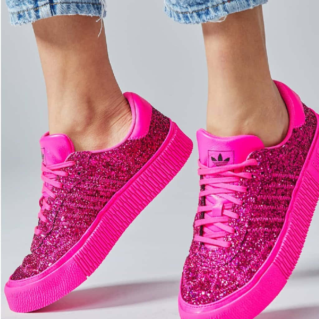 Pink Shoes 桌布 壁紙 — 鮮豔的粉紅色亮片運動鞋，搭配厚底，與捲起的牛仔褲一起穿著，背景為純色。