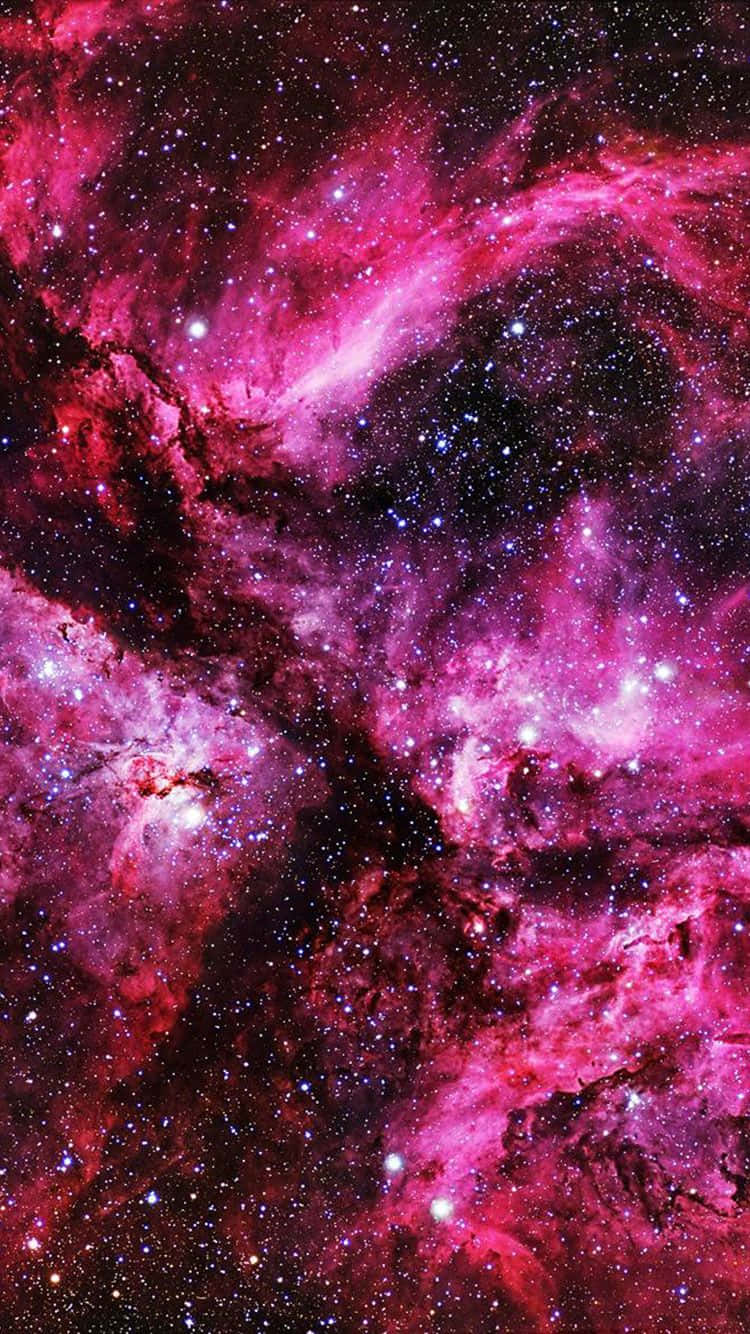 粉紅色 iPhone 桌布 壁紙 — 鮮豔的粉紅色和紫色宇宙雲層在深邃的黑色虛空中與發光的星星旋轉，形成壯麗的太空星雲。