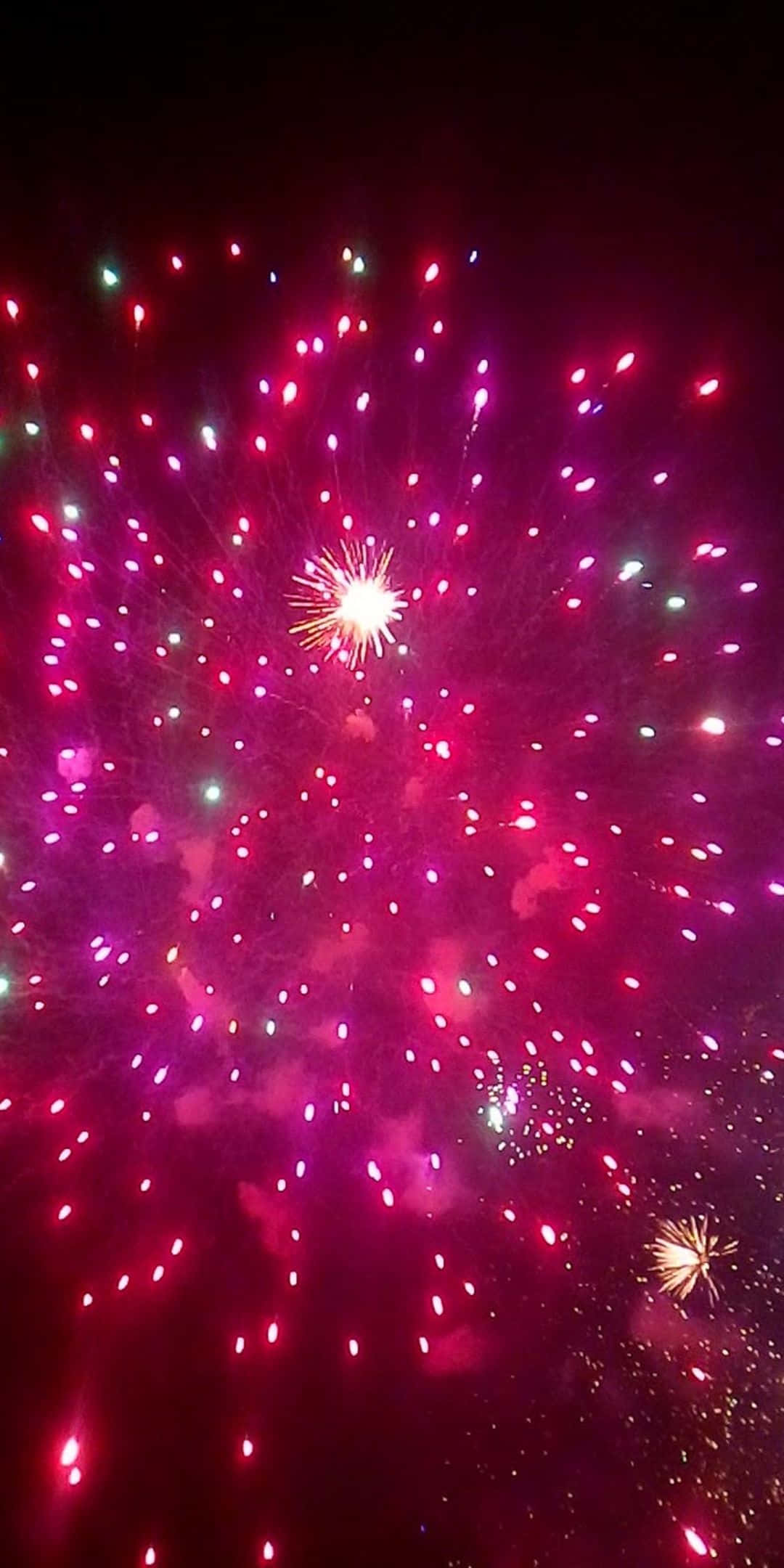 粉紅色 桌布 壁紙 — 鮮豔的粉紅色和綠色煙火在黑暗的夜空中綻放出耀眼的光芒。
