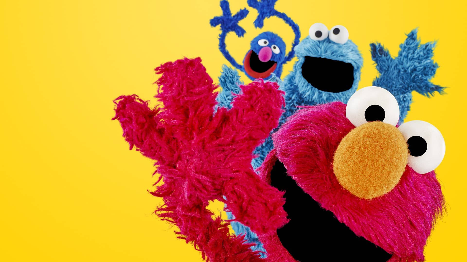 Elmo 桌布 壁紙 — 鮮豔的粉紅色和藍色毛絨公仔 Elmo 和 Cookie Monster 在明亮的黃色背景前愉快地擺姿勢。