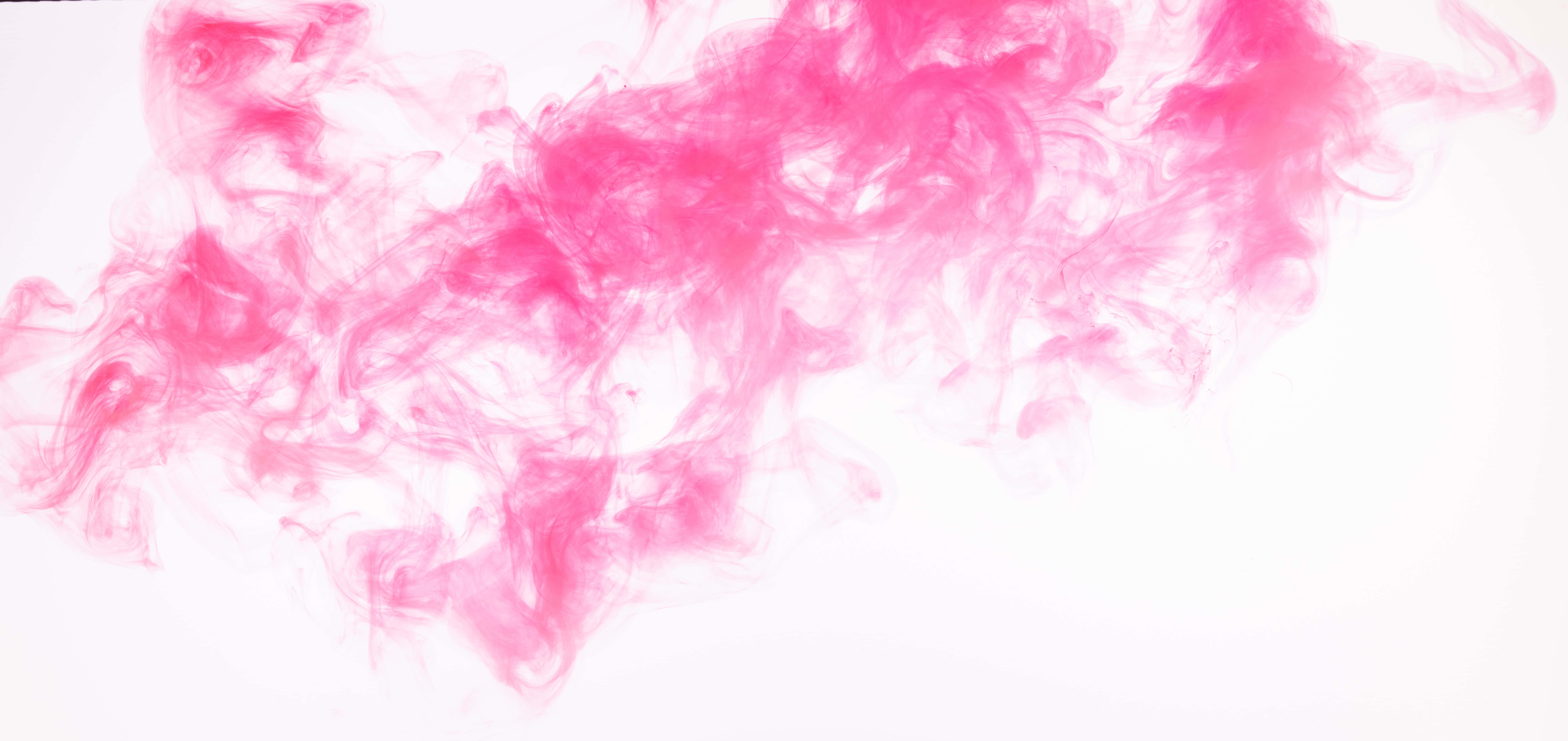 Pink Smoke 桌布 壁紙 — 鮮豔的粉紅色墨水漩渦在純白背景上優雅地旋轉，形成流暢的抽象構圖。