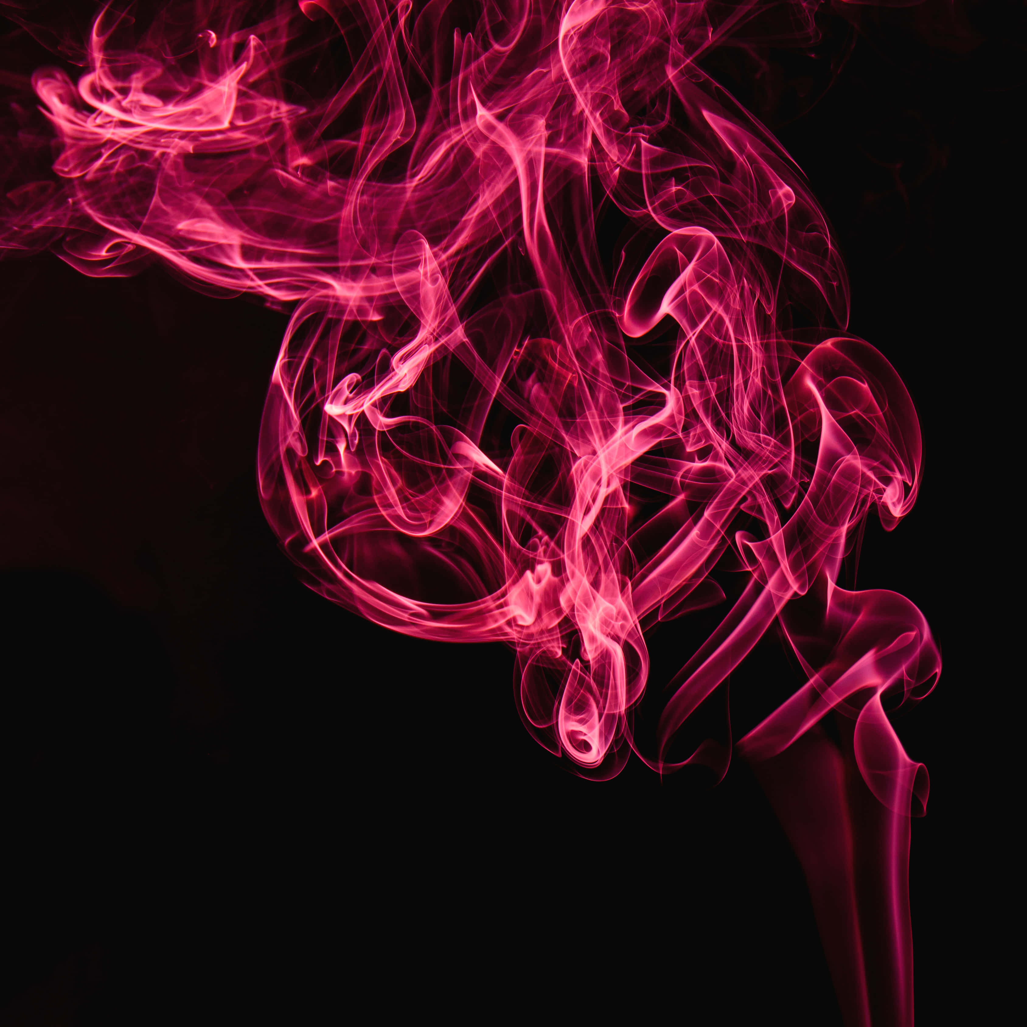 Red Smoke Effect 桌布 壁紙 — 鮮豔的粉紅色煙霧在深黑色背景上動態旋轉，營造出空靈而神秘的視覺效果。
