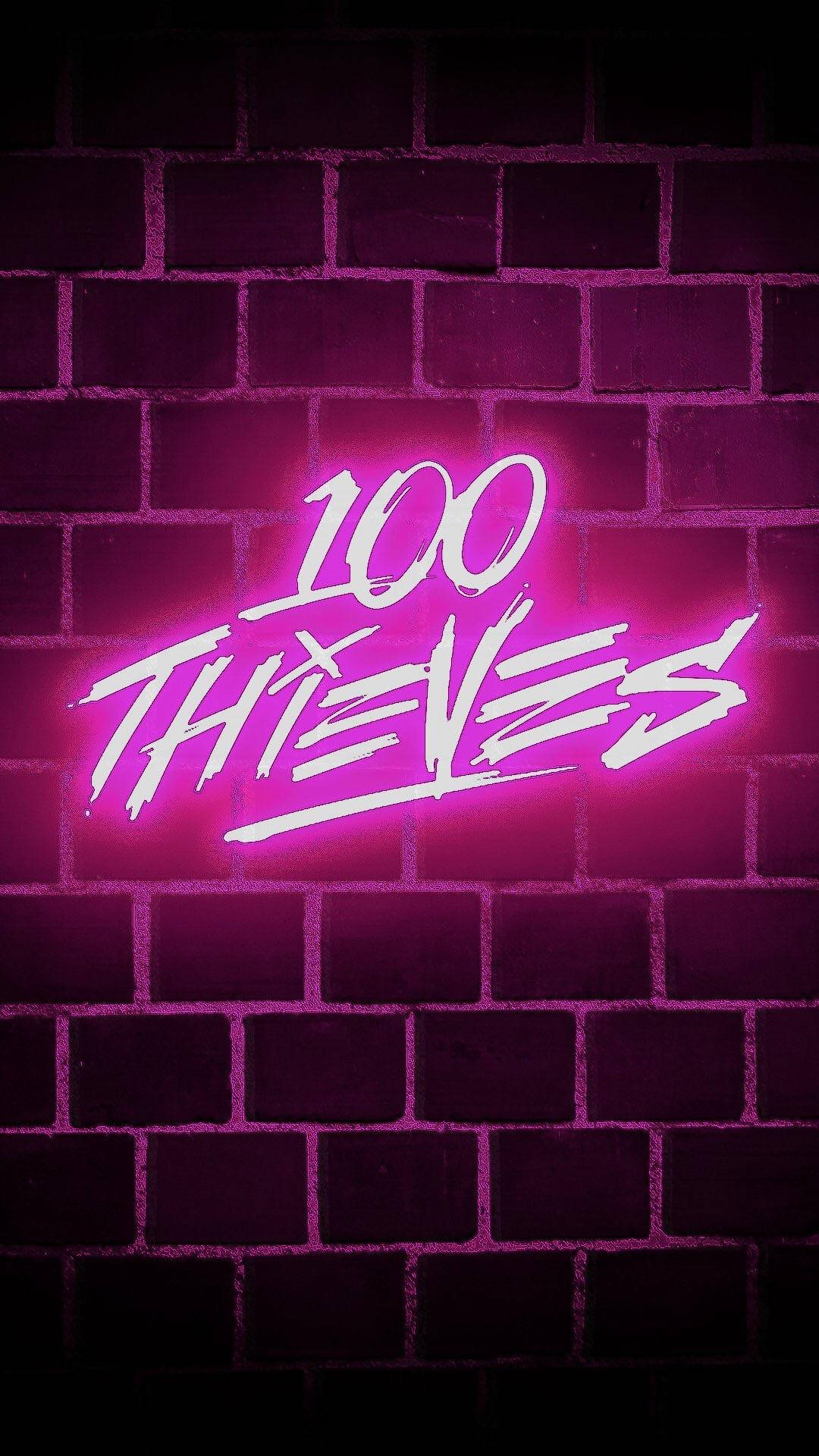 Brick Wall 桌布 壁紙 — 鮮豔的粉紅色霓虹燈招牌寫著 100 THIEVES，在黑暗的磚牆上發光，營造出粗獷的城市氛圍。