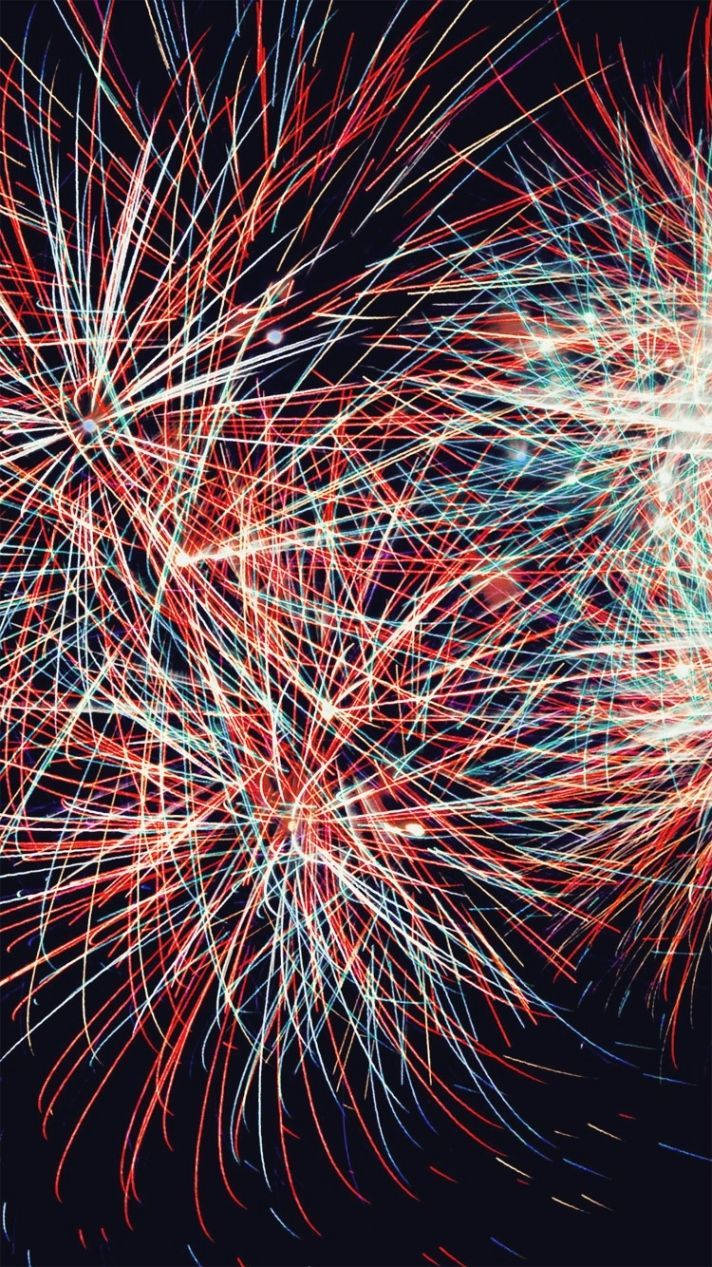 4th Of July 桌布 壁紙 — 鮮豔的紅、白、藍色煙火在黑暗的夜空中爆炸成條紋，創造出耀眼的慶祝展示。