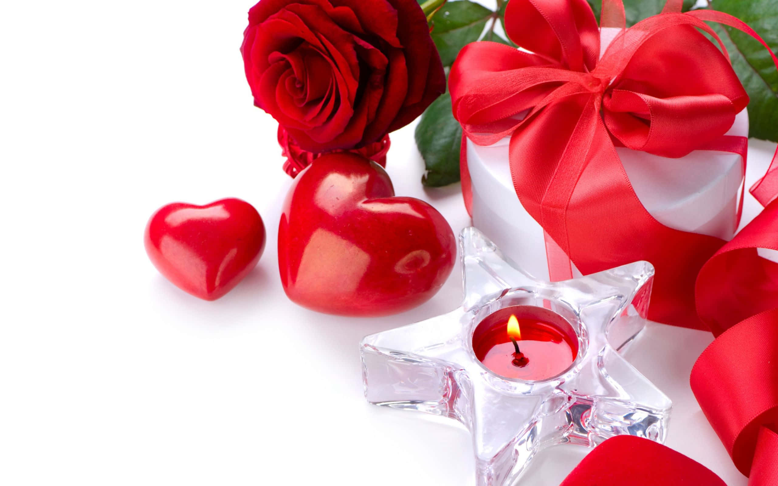Red Rose 桌布 壁紙 — 鮮豔的紅玫瑰、光澤的心形禮物盒和星星蠟燭，在白色背景上營造出浪漫的情人節靜物。
