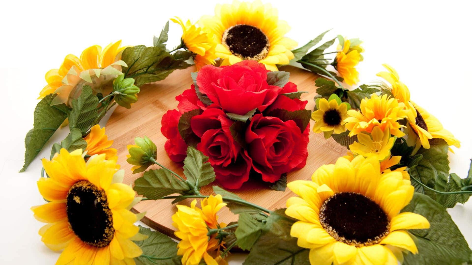 Roses 桌布 壁紙 — 鮮豔的紅玫瑰和明亮的黃色向日葵在白色背景的木板上排列成圓形花環。