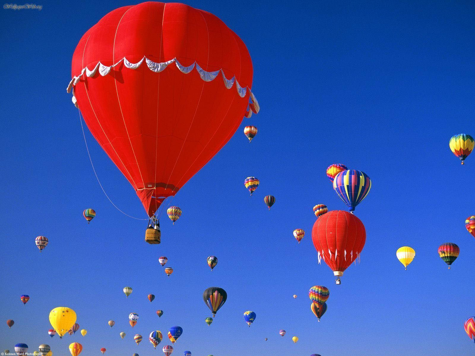 Balloon 桌布 壁紙 — 鮮豔的紅色、黃色和彩虹色調的熱氣球，在清澈深藍的天空中優雅地飄浮。