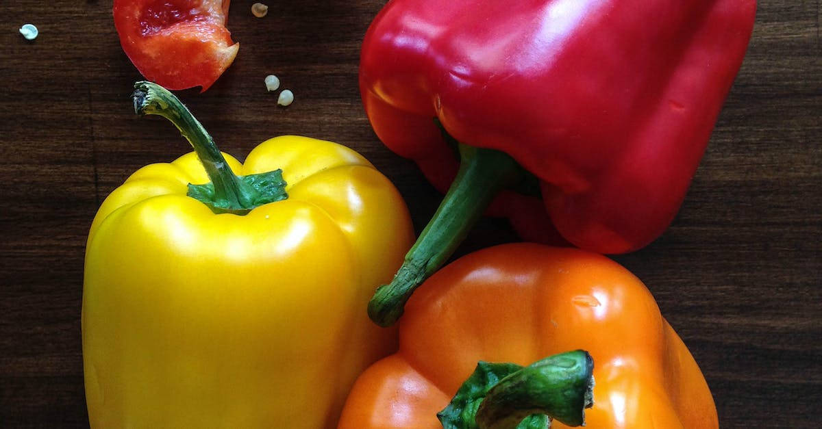 Fruits 桌布 壁紙 — 鮮豔的紅色、黃色和橙色甜椒與番茄籽放在深色木質表面上。