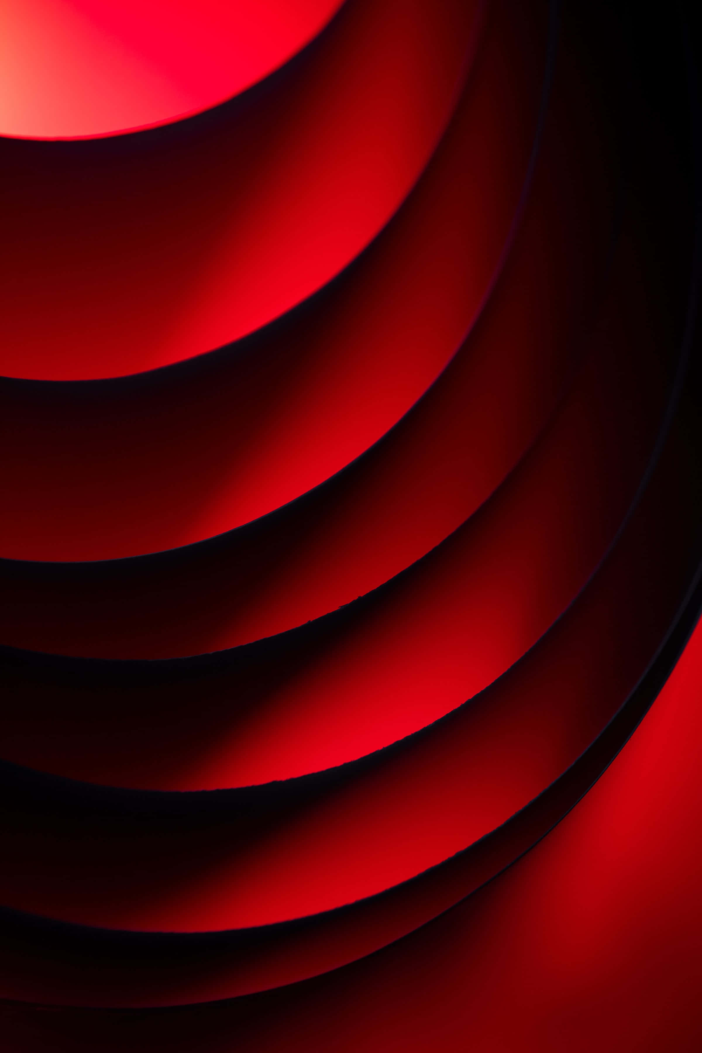 circles 桌布 壁紙 — 鮮豔的紅色同心曲線在深色陰影中發光，營造出大膽的抽象構圖。