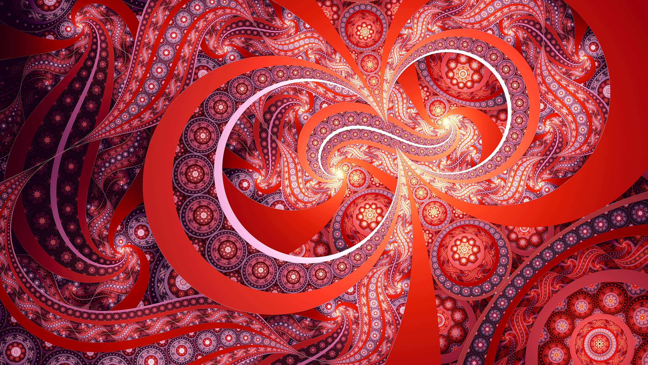 Trippy Fractals 桌布 壁紙 — 鮮豔的紅色和橙色碎形圖案在催眠般的螺旋中旋轉，帶有發光的中心和複雜的佩斯利細節。