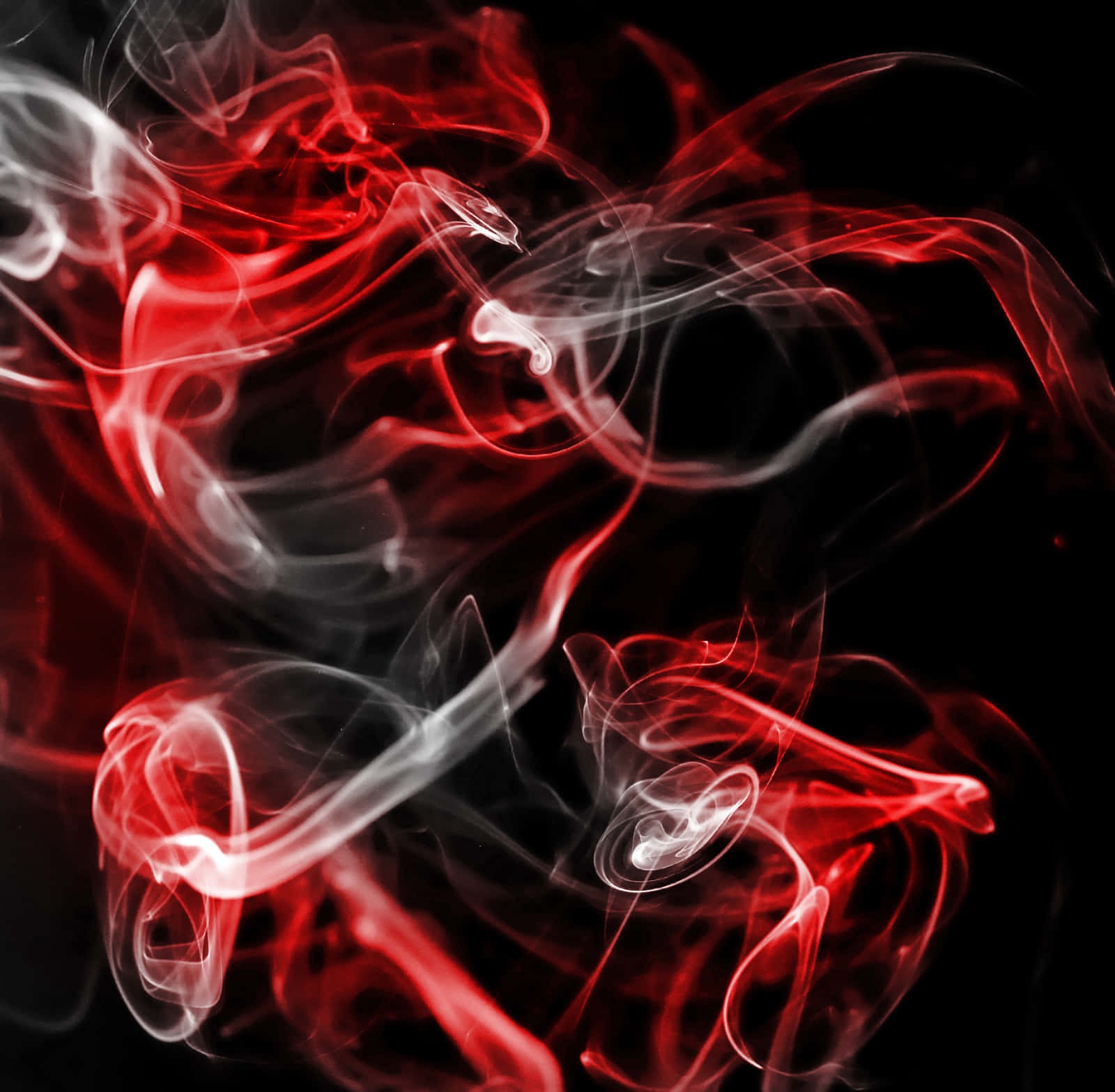 Red Smoke Effect 桌布 壁紙 — 鮮豔的紅色和白色煙霧在純黑色背景上動態旋轉，營造出強烈的抽象運動感。