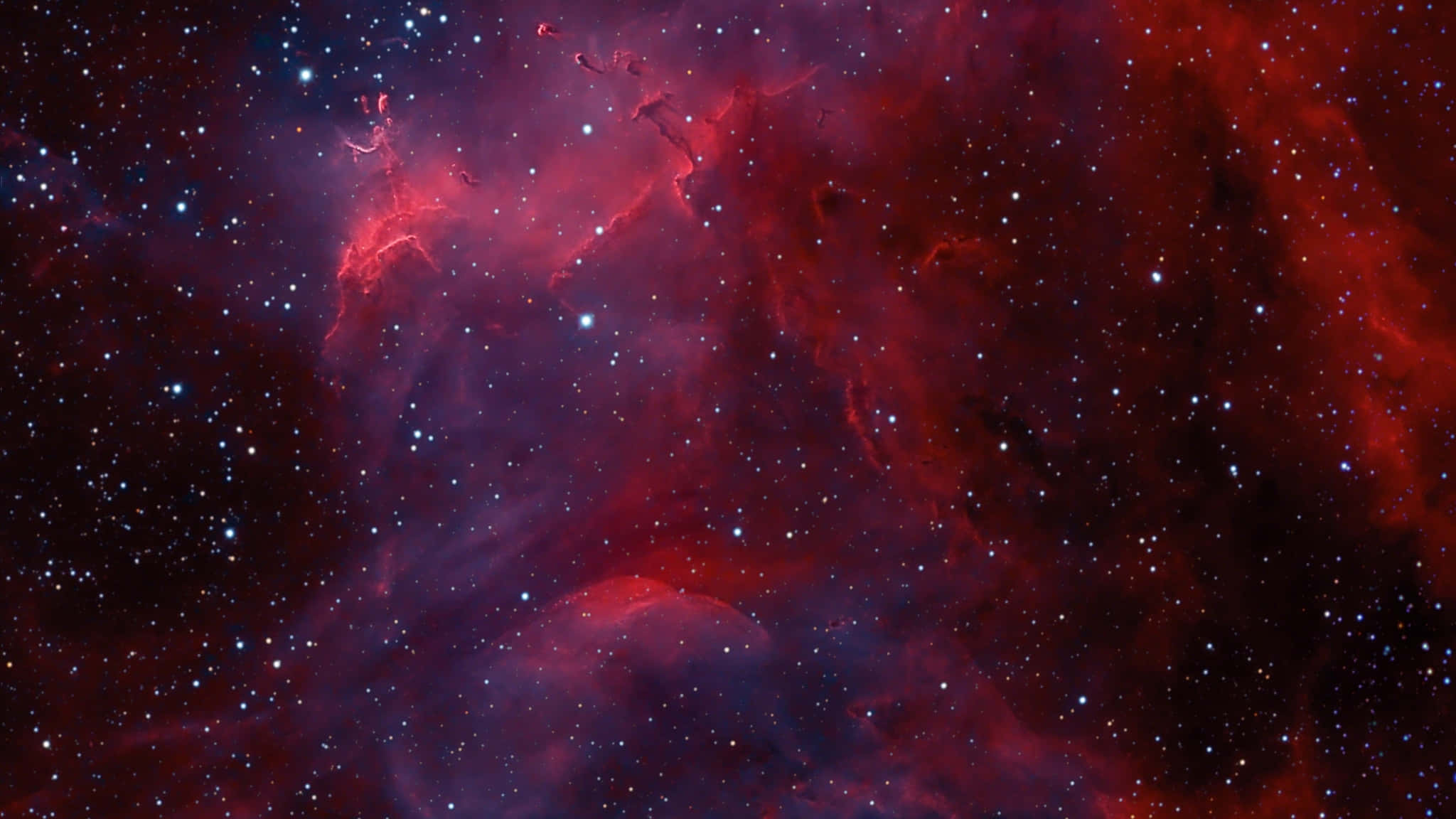 2048x1152 桌布 壁紙 — 鮮豔的紅色和紫色宇宙星雲，在黑暗虛空中閃爍著散落的明亮星星。