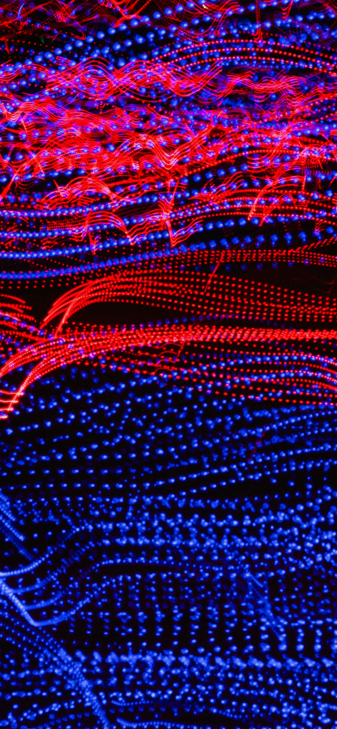 Red And Blue iPhone 桌布 壁紙 — 鮮豔的紅色和藍色光軌在黑色背景上動態旋轉，形成迷人的抽象數位圖案。