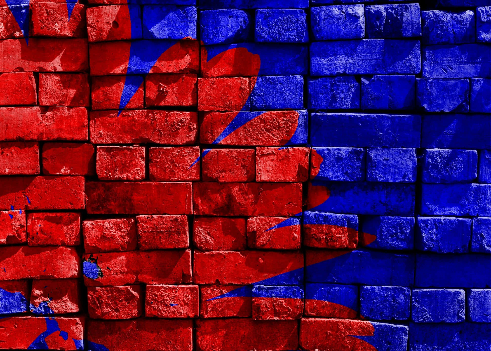 Brick Wall 桌布 壁紙 — 鮮豔的紅色和藍色塗鴉藝術以大膽的抽象圖案濺在風化的磚牆上。