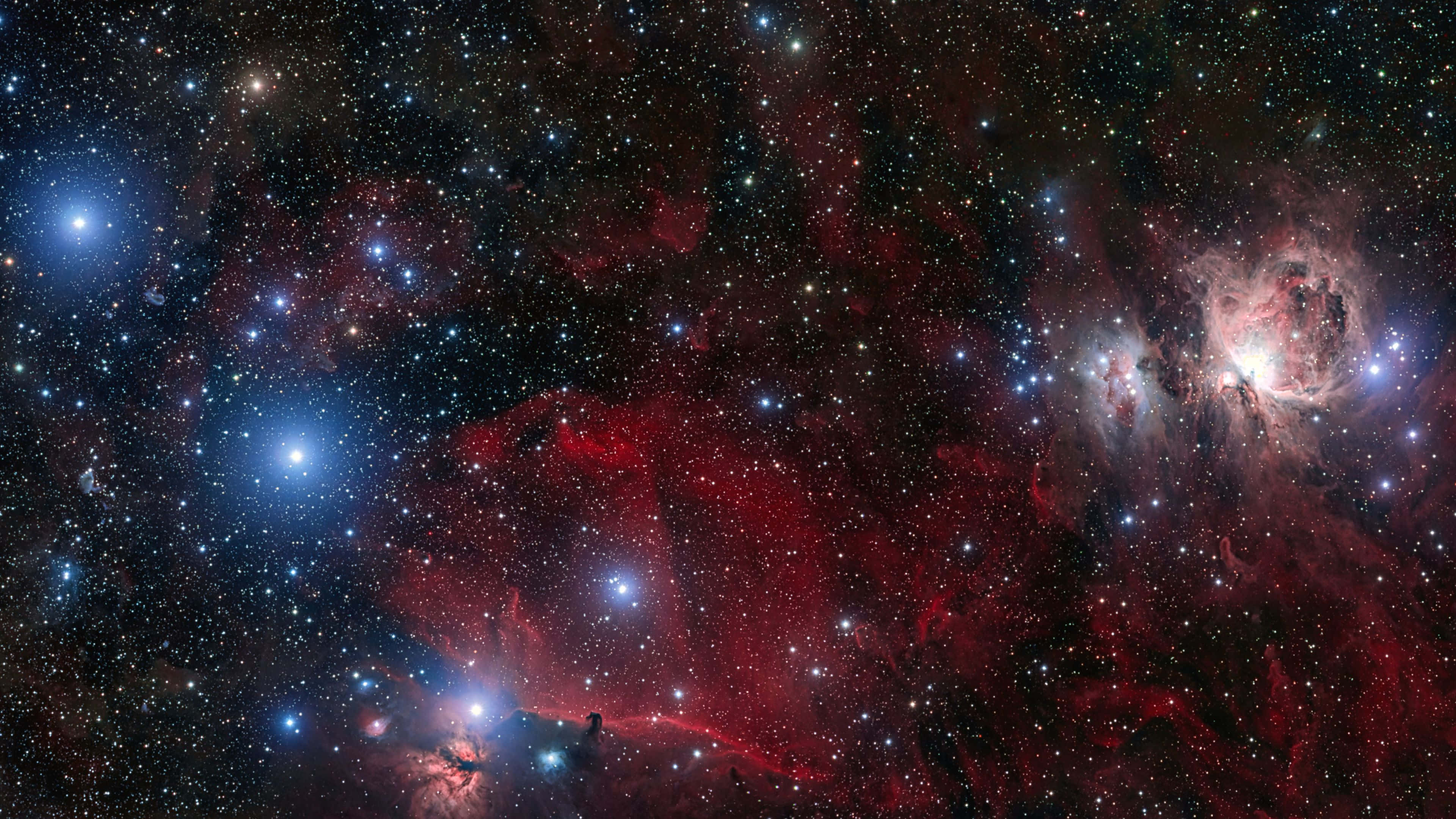 Starry 桌布 壁紙 — 鮮豔的紅色和藍色星雲在深邃的宇宙中，伴隨著無數星星閃耀。
