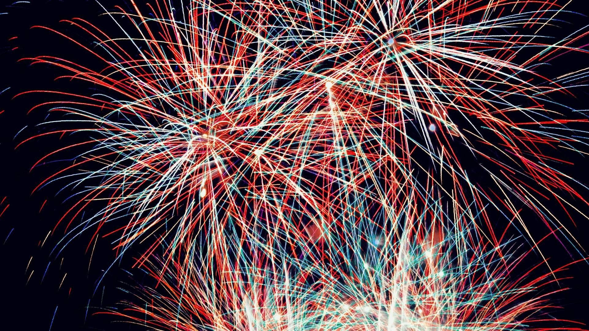 4th Of July 桌布 壁紙 — 鮮豔的紅色和藍色煙火在深邃的黑色夜空中綻放出耀眼的光芒。