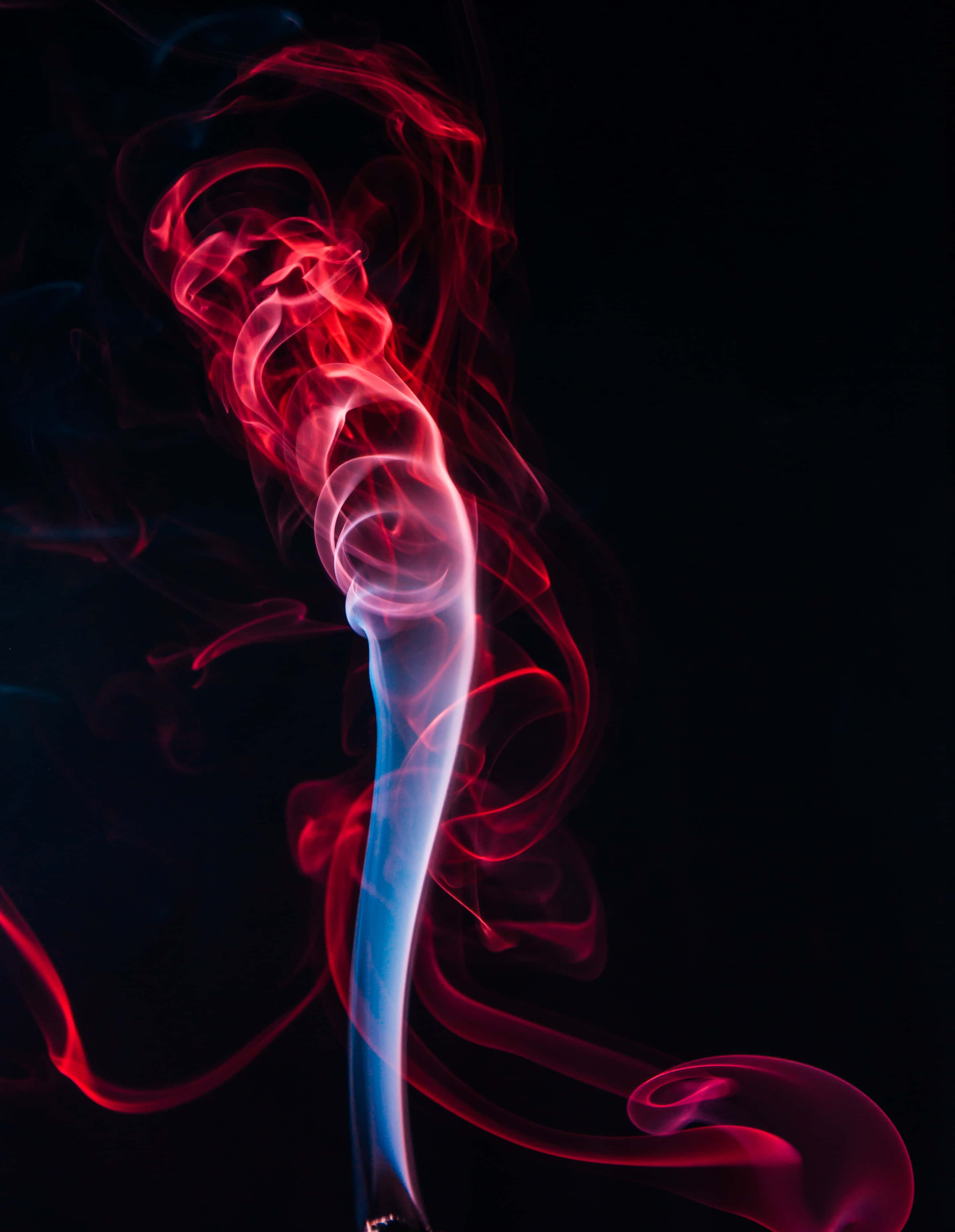 Smokey 桌布 壁紙 — 鮮豔的紅色和藍色煙霧在深黑色背景上優雅地旋轉，形成迷人的抽象舞蹈。
